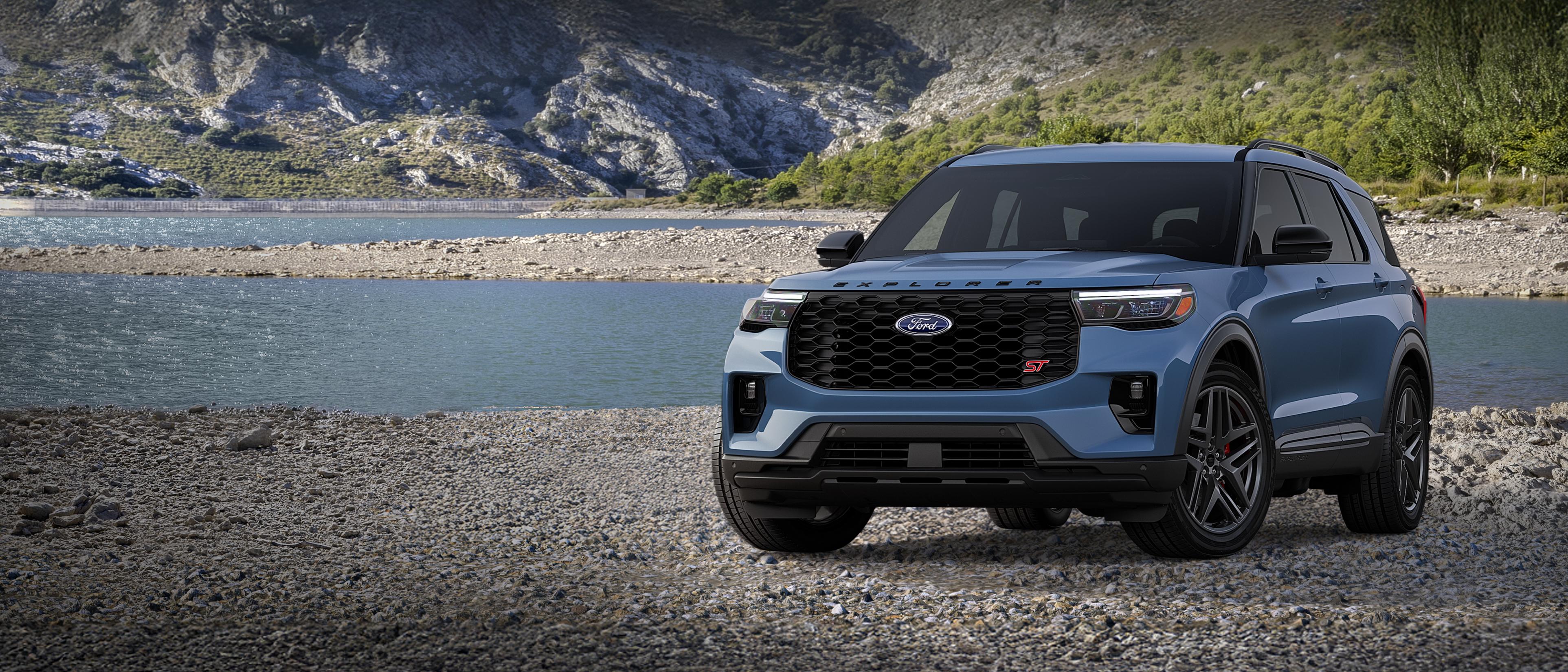 A 2026 Ford Explorer® ST model parked on a rocky expanse near a mountain lake