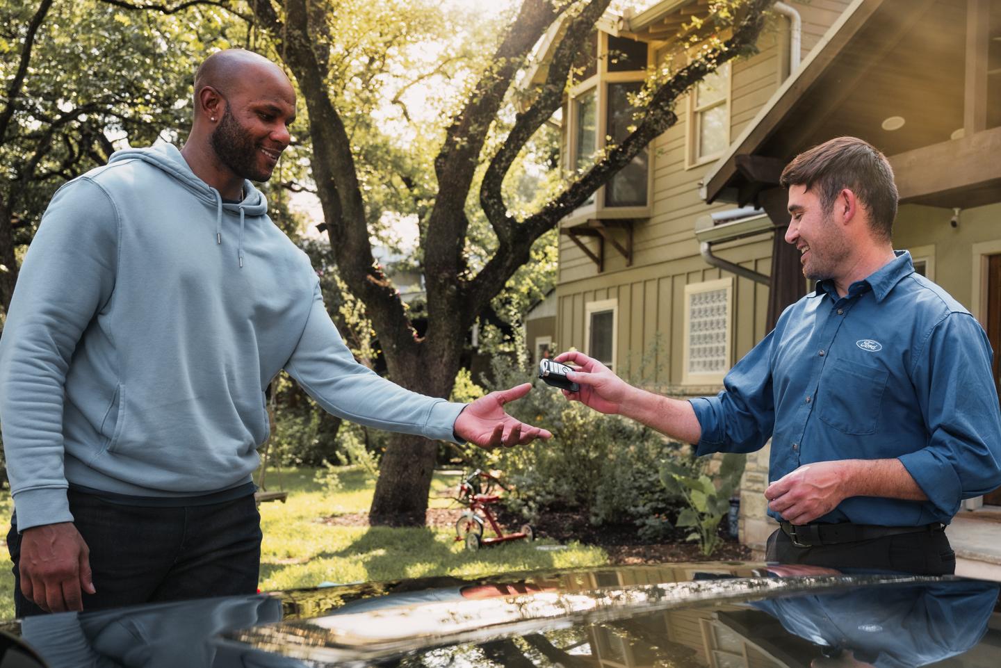 A Ford associate hands a driver the key fob for their vehicle