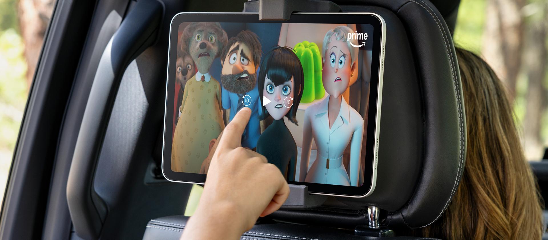 Passenger using a tablet in the available second-row digital device holder in a 2026 Ford Expedition® SUV