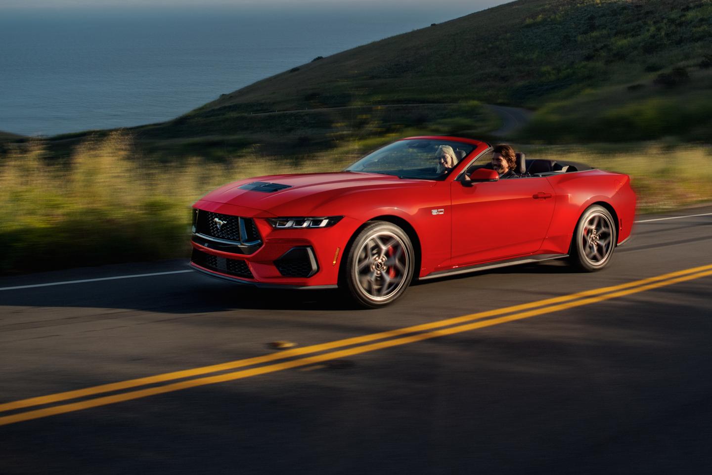 Mustang convertible driving on a two-lane highway.