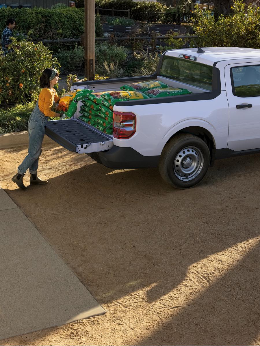 Two people load a Maverick truck bed.