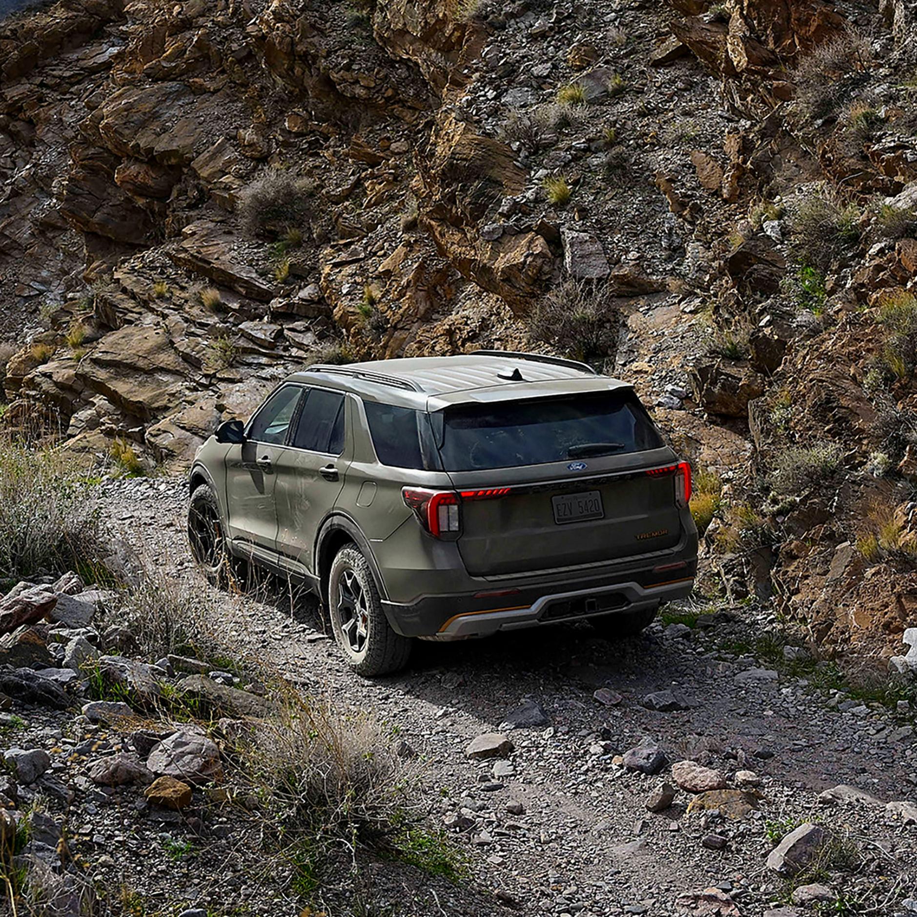 A 2027 Ford Explorer® Tremor® SUV being driven on a trail through rocky hills