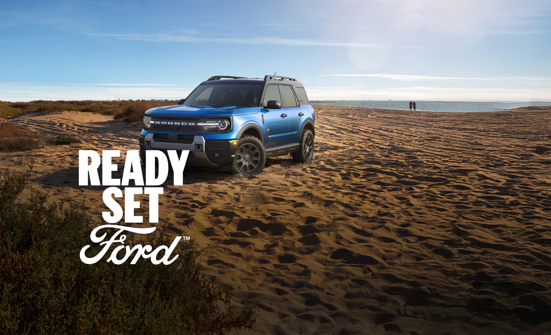 Three-quarter front view of a blue Ford Bronco Sport parked in a desert. White text “Ready Set Ford” appears in the lower left-hand corner. 
