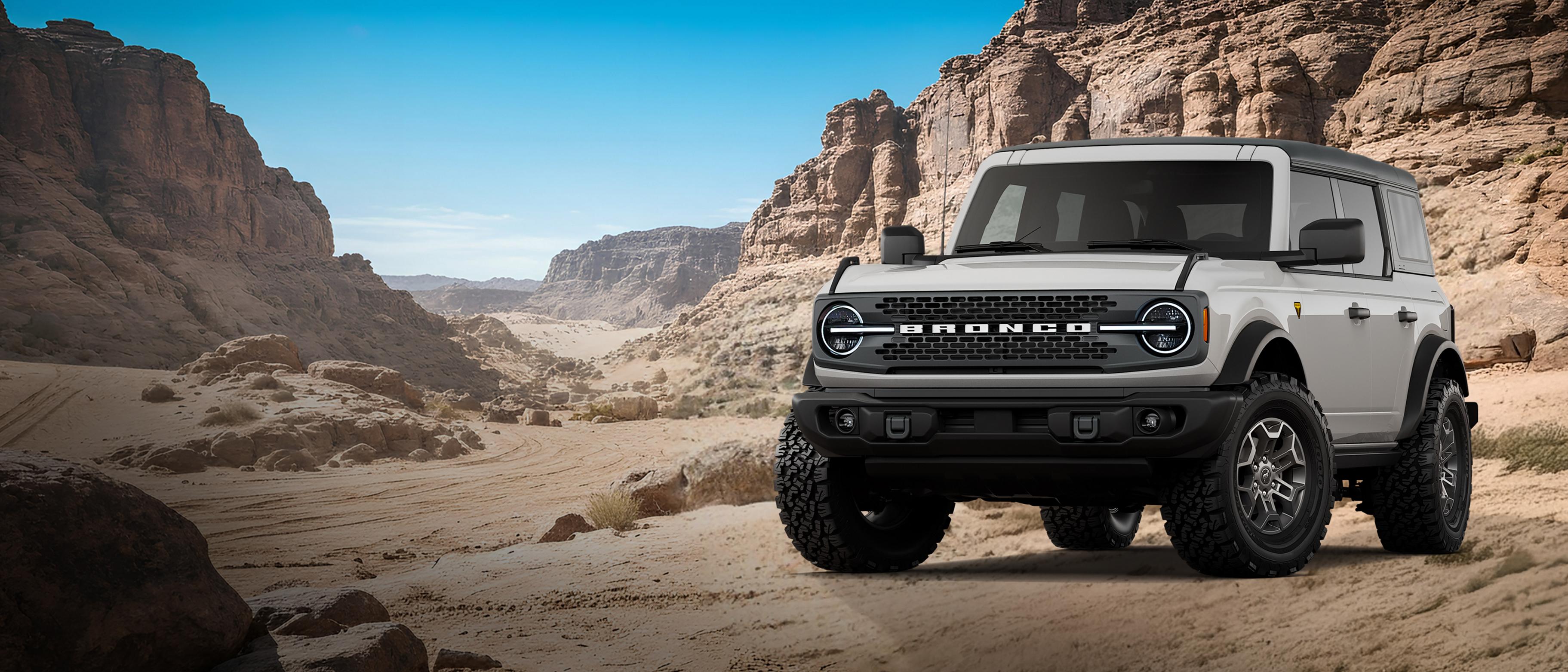 A 2026 Ford Bronco® Badlands model shown in Avalanche Grey parked on a rocky expanse