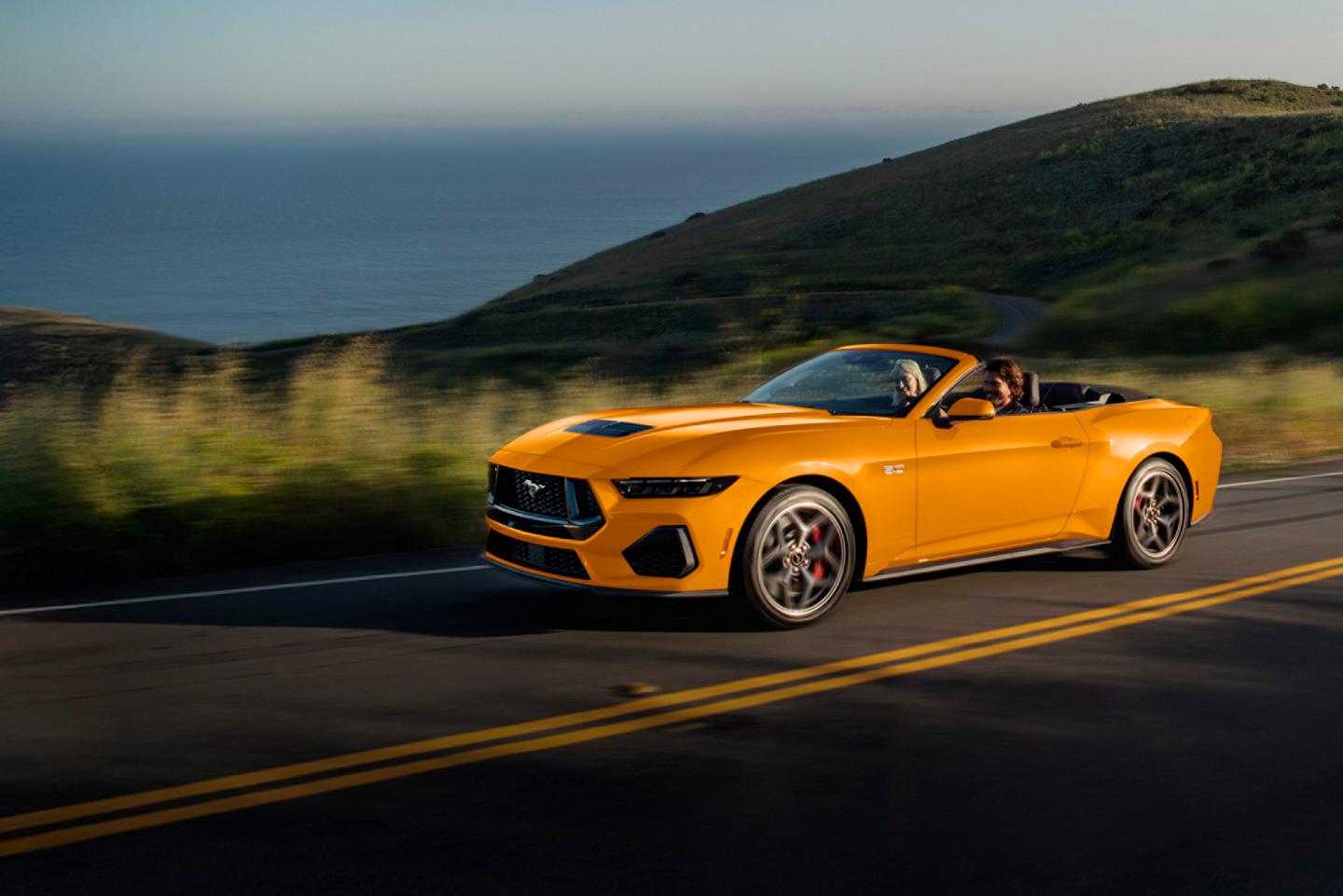 A 2026 Ford Mustang® GT Premium Convertible model being driven on a seaside highway