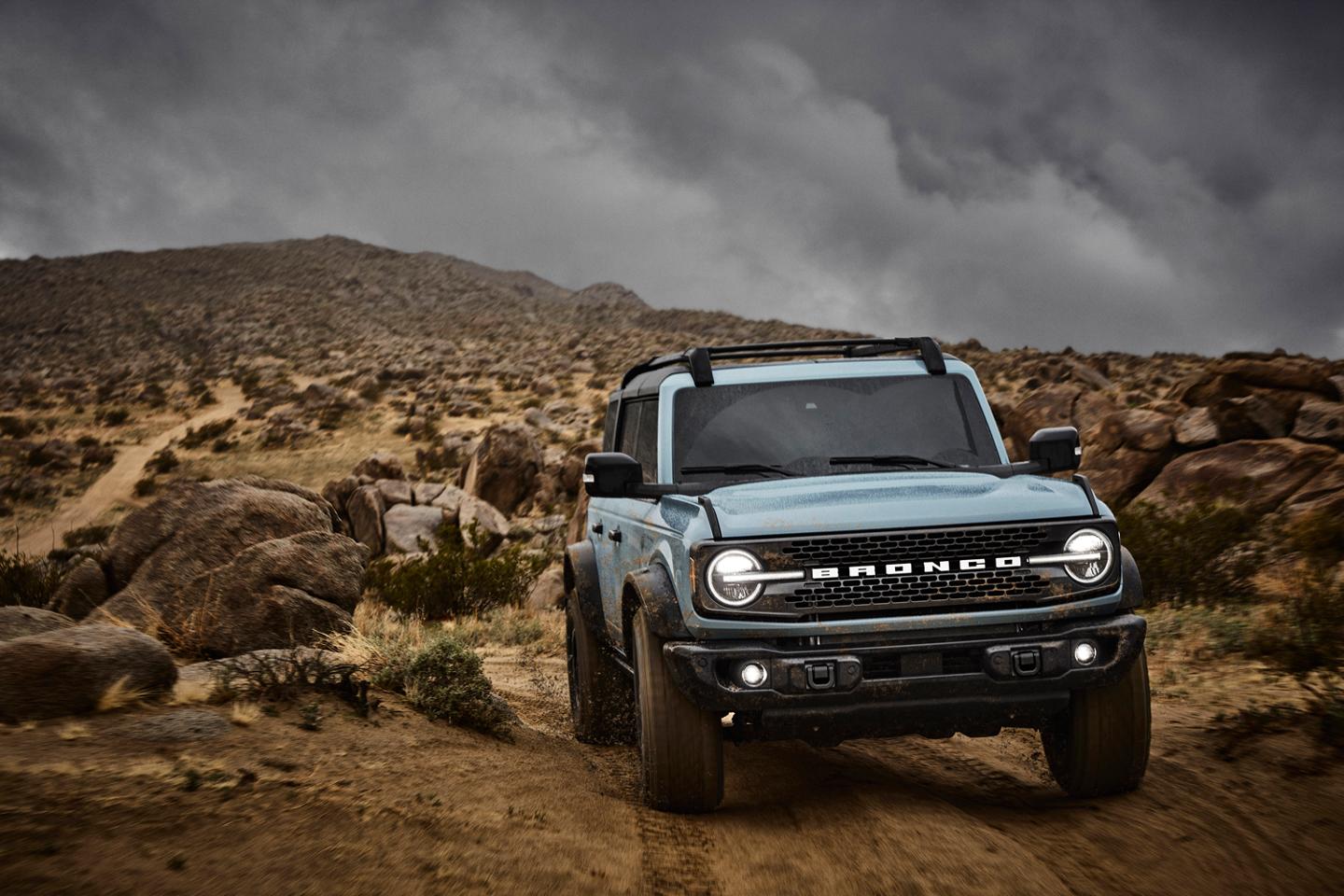 A 2025 Ford Bronco® SUV driving on a dirt trail in the high desert