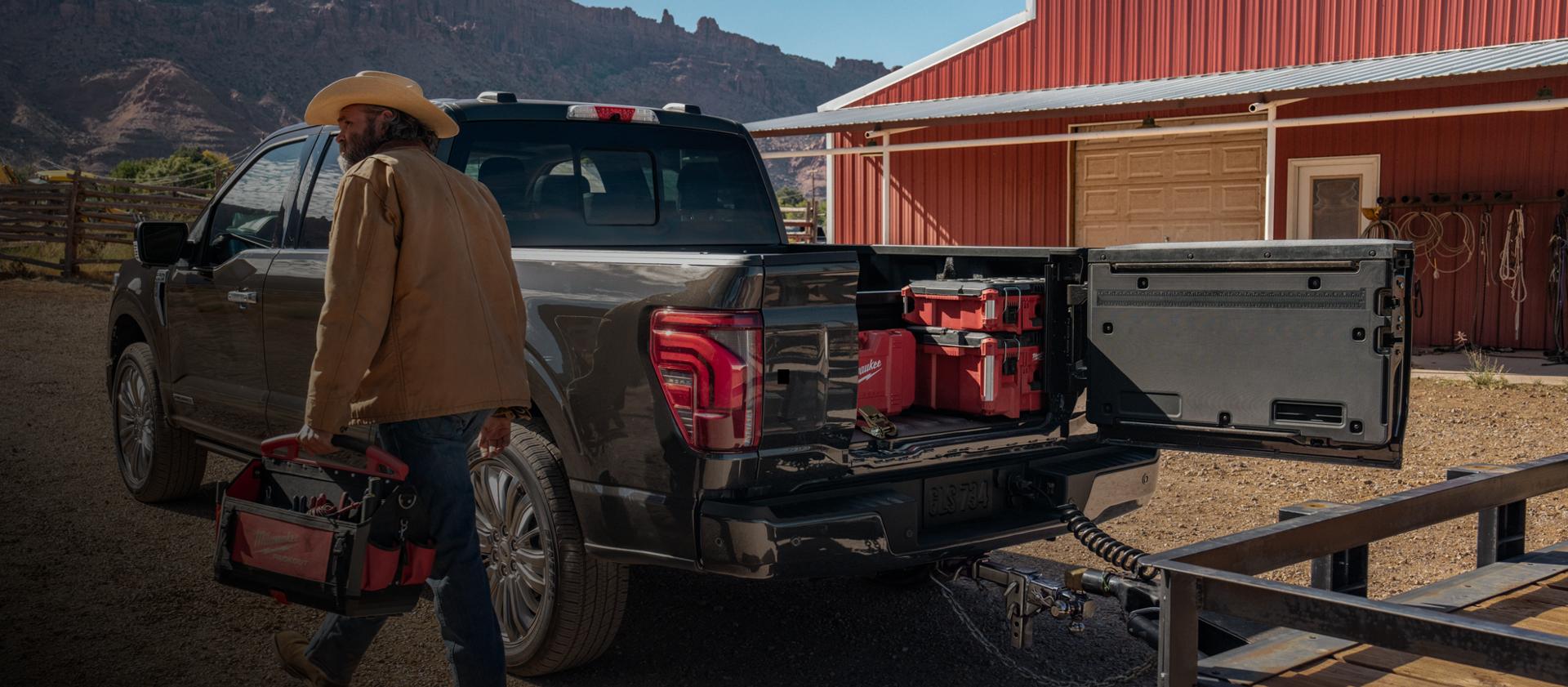 Person walking near a 2025 Ford F-150® pickup with the Pro Access tailgate open