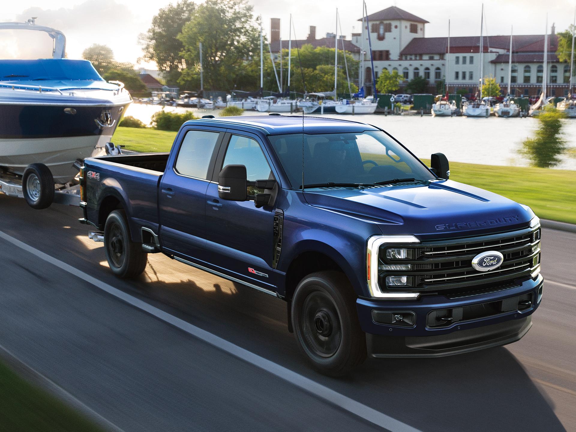 2027 Ford Super Duty® F-350® Platinum® model towing a speed boat on a paved road