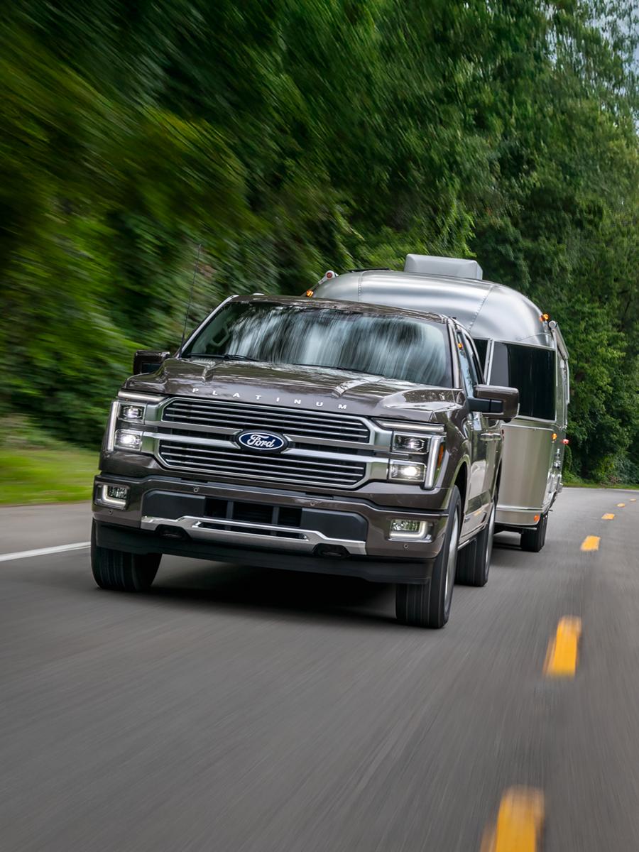 2026 Ford F-150® Platinum truck in Marsh Grey pulling a camper