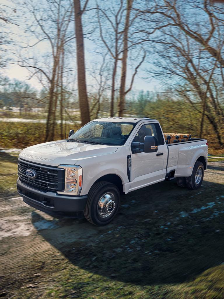 2026 Ford Super Duty® F-350® XL driving on a dirt road with a full truck bed