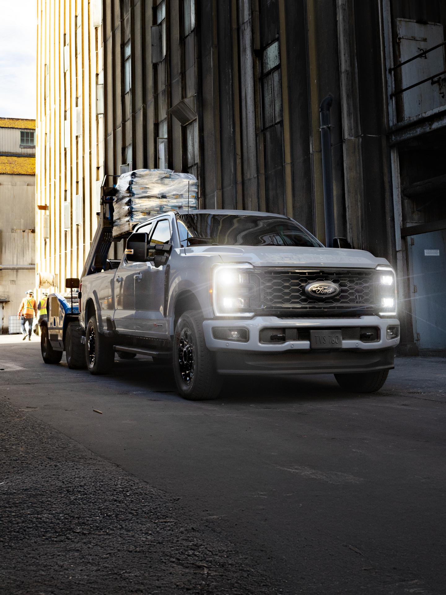 Super Duty parked at a work site with hitched trailer loaded with steel tubing.