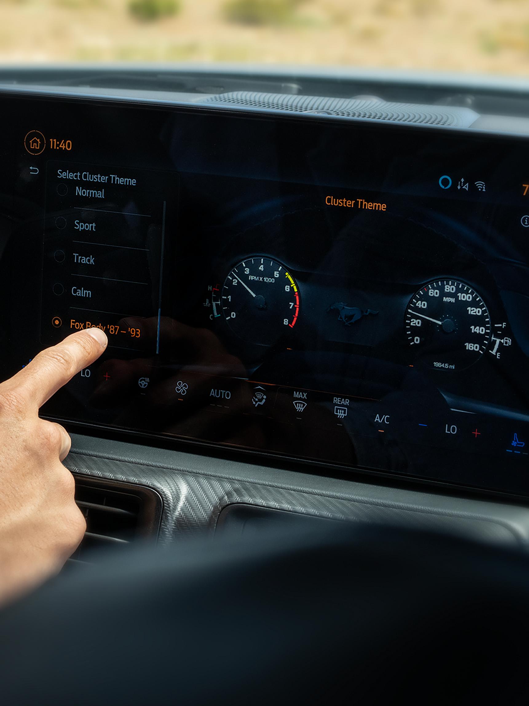 Person using the 2026 Ford Mustang® fastback centre display with the available magnesium-framed panoramic curved display