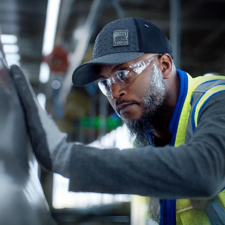 A Ford employee works on a vehicle.