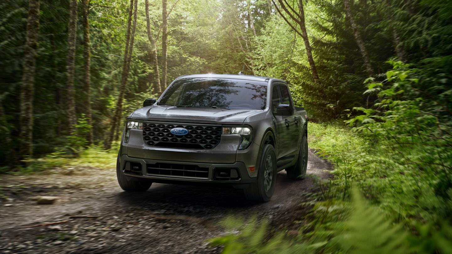 A 2026 Ford Maverick® XLT model with FX4® Off-Road Package being driven on a muddy forest trail