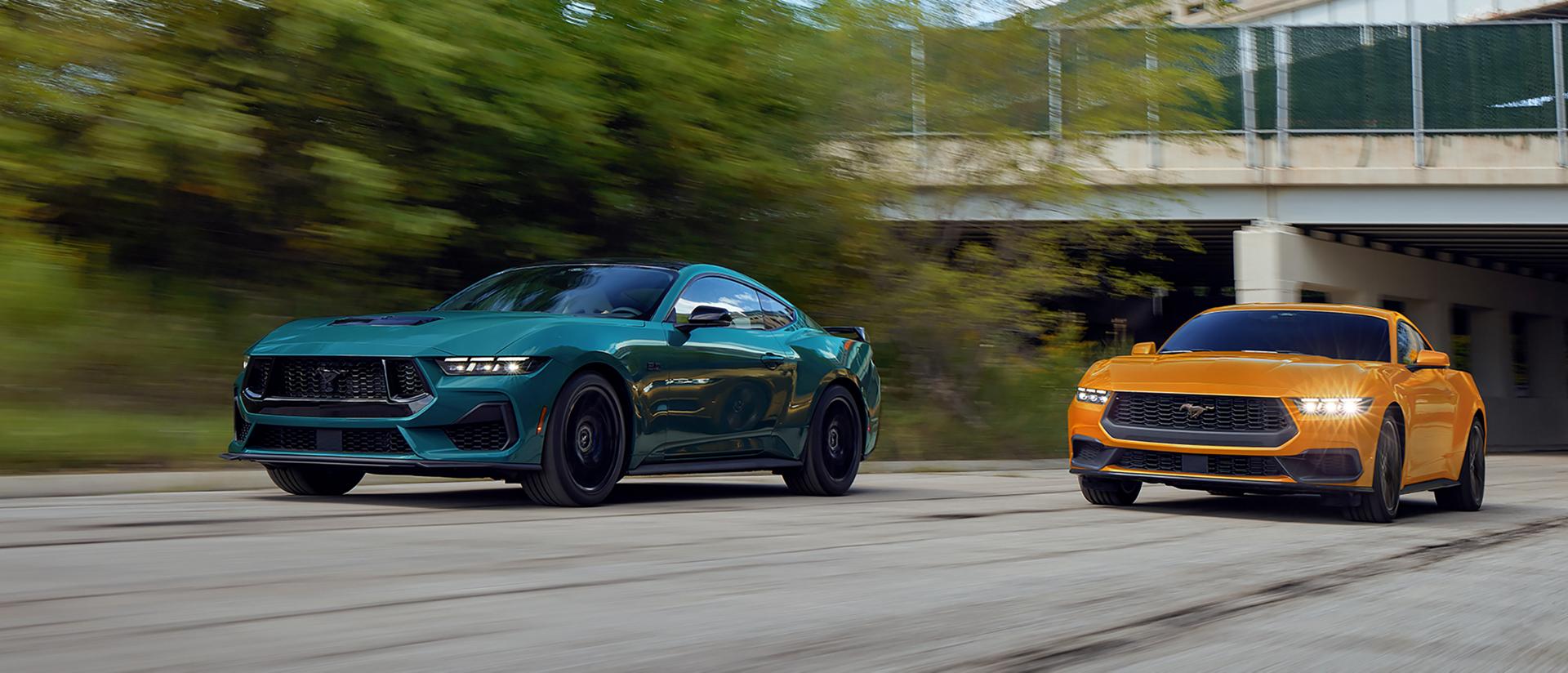 A 2026 Ford Mustang® GT fastback and a Mustang® EcoBoost® fastback being driven on a highway