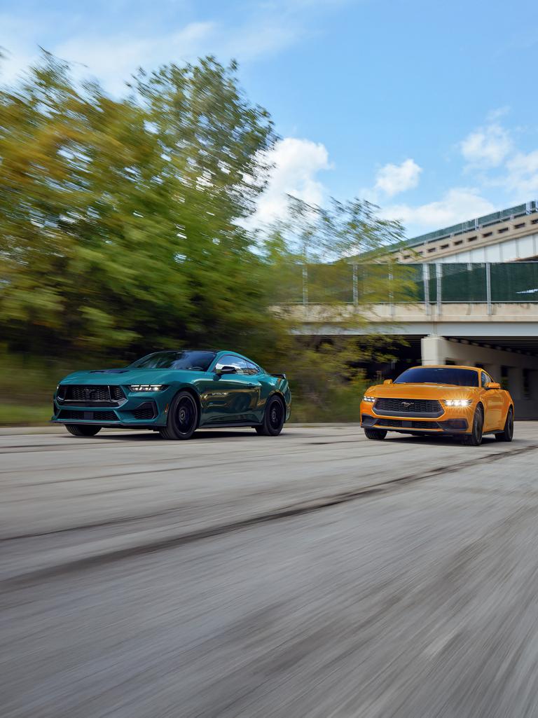 A 2026 Ford Mustang® GT fastback and a Mustang® EcoBoost® fastback being driven on a highway