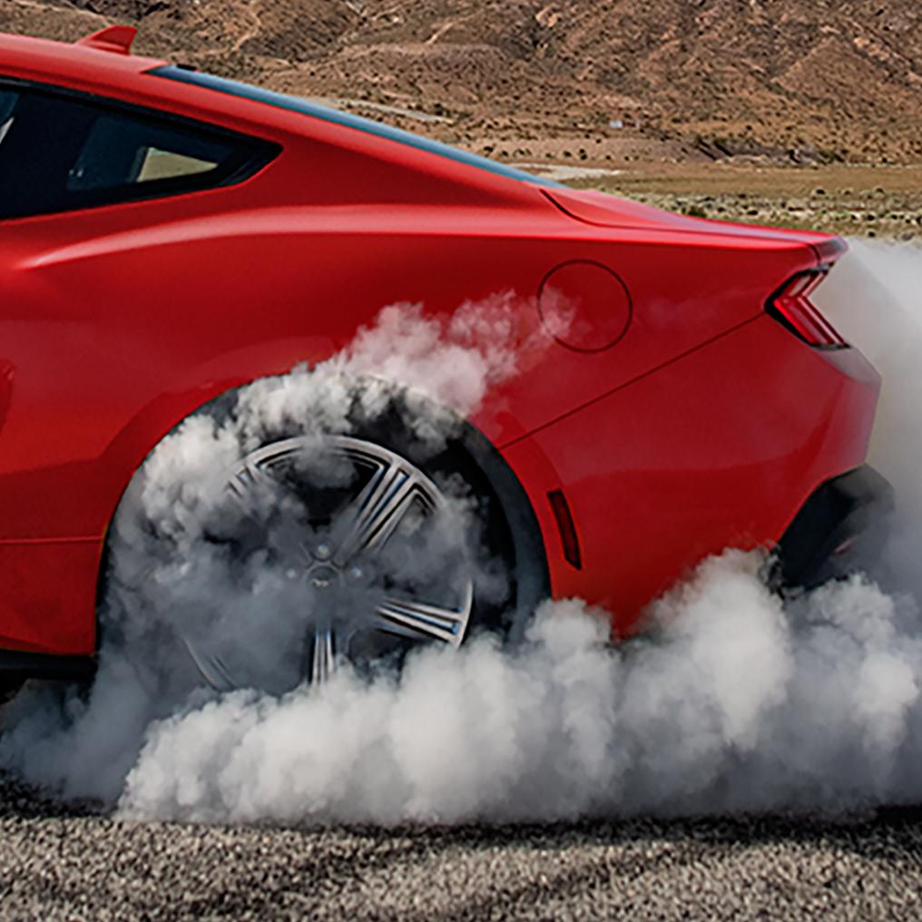2026 Ford Mustang® EcoBoost® in Grabber Blue spinning around with smoke coming out of back tire