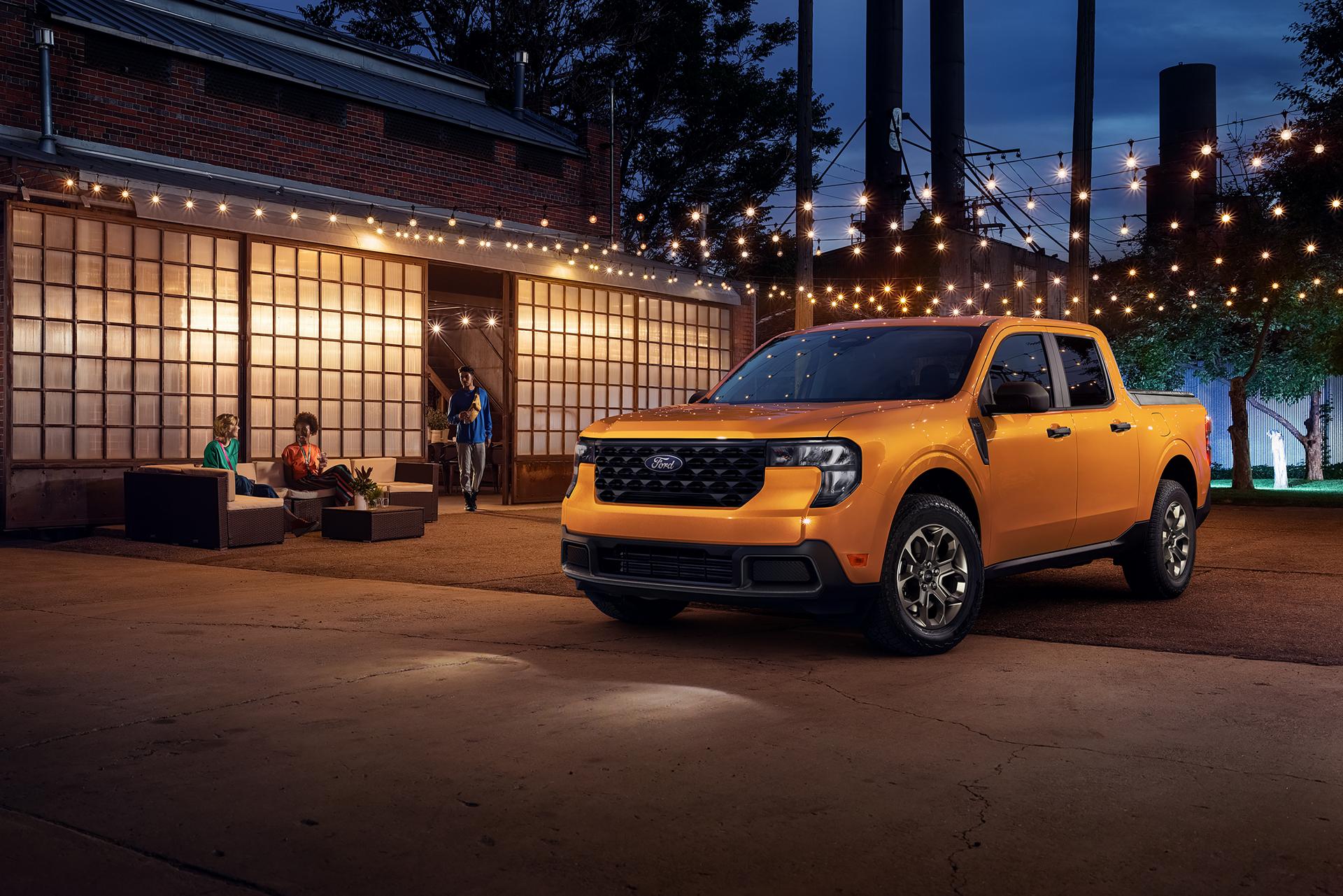 Ford Maverick® XLT model in Orange Fury parked under lights next to a building at night