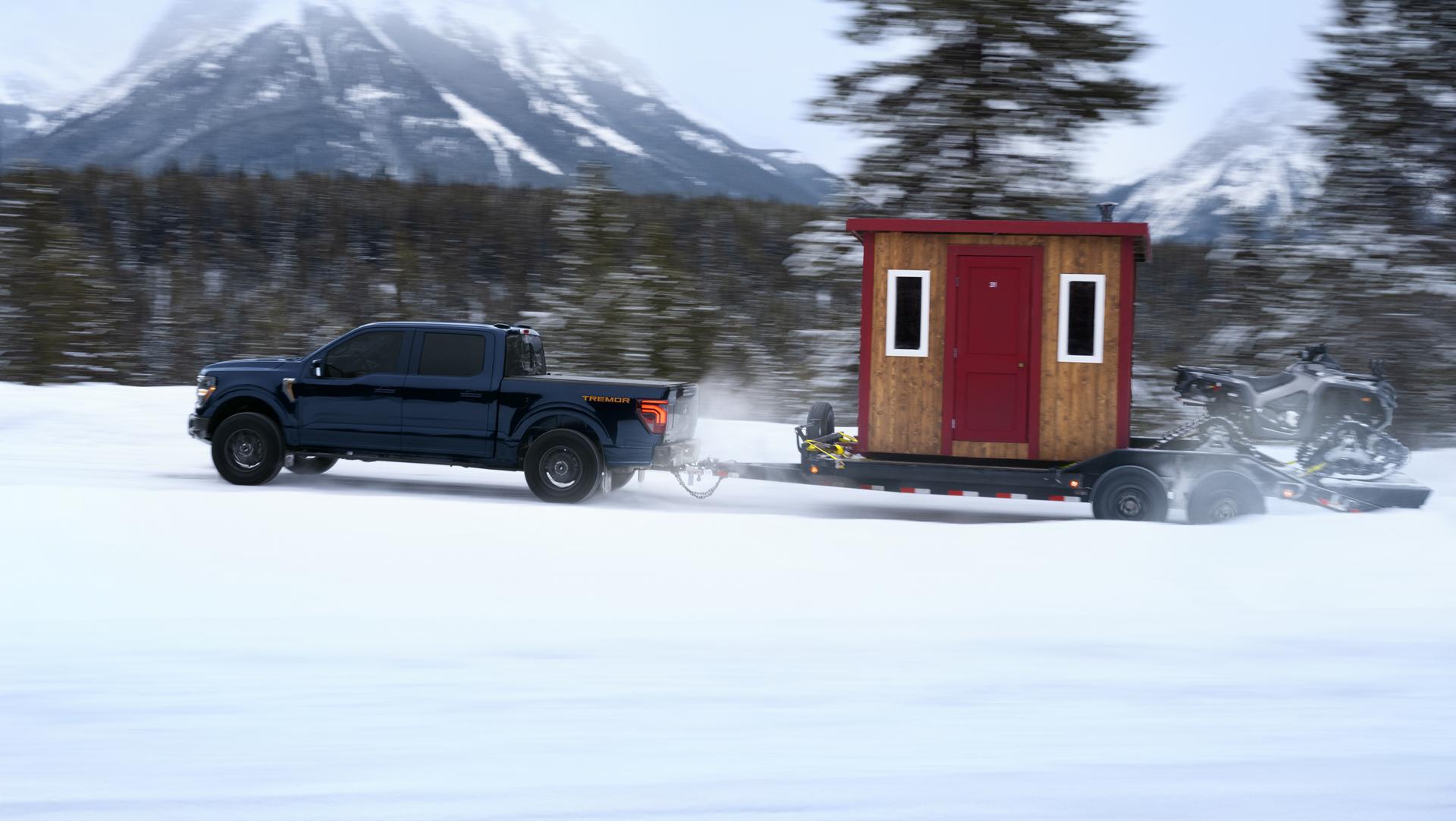F-150 Tremor hauling an ice fishing hut and ATV on an icy mountain road.