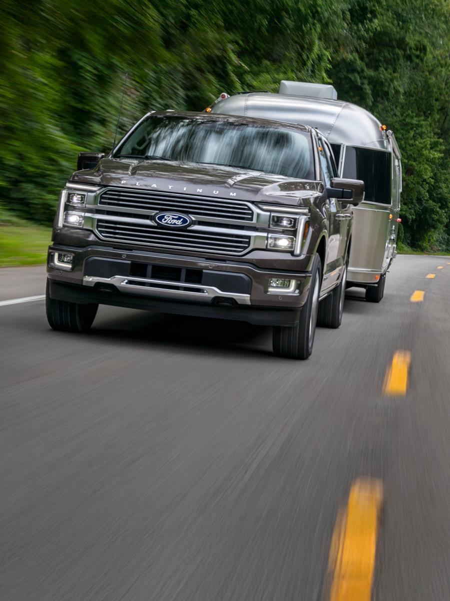 F-150 towing an RV on a two-lane highway.