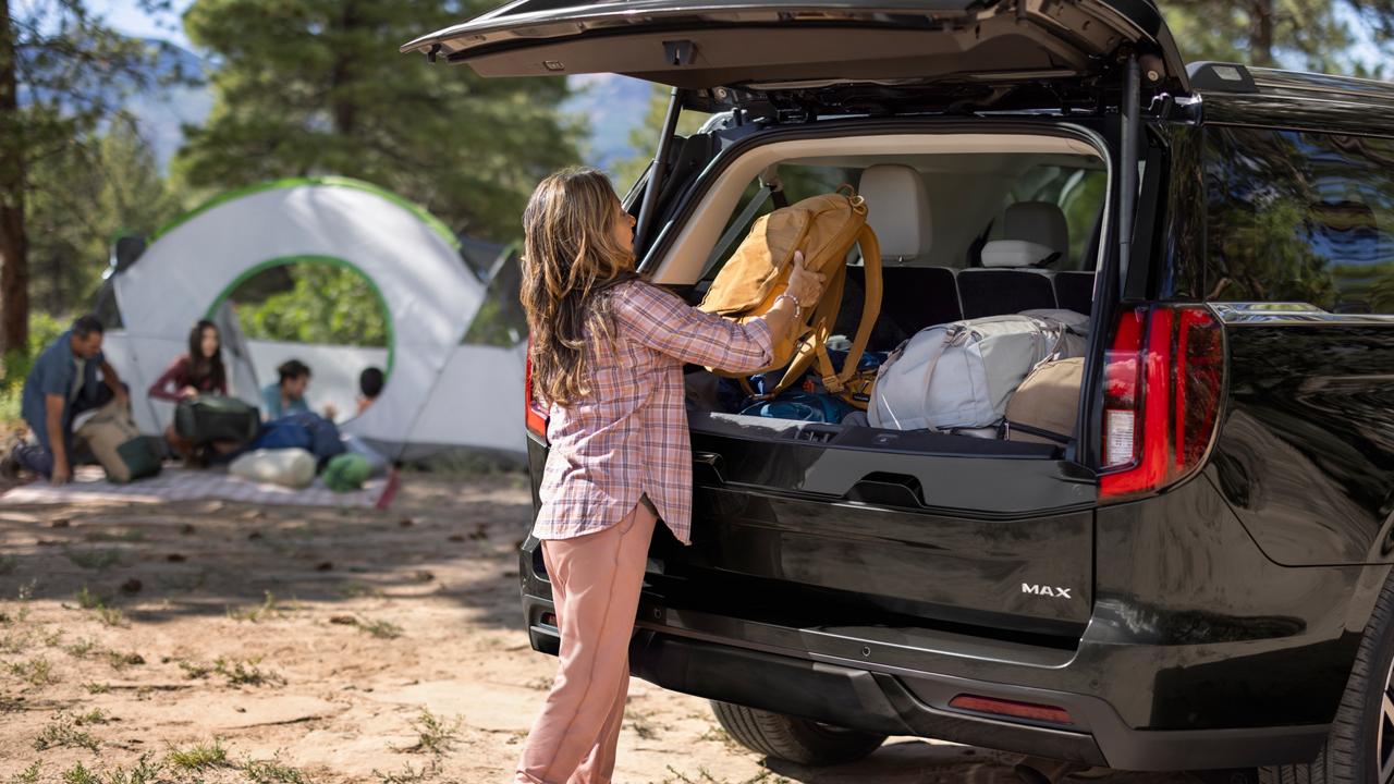 Person loading bags into the rear cargo area of a 2027 Ford Expedition® MAX Platinum™ SUV