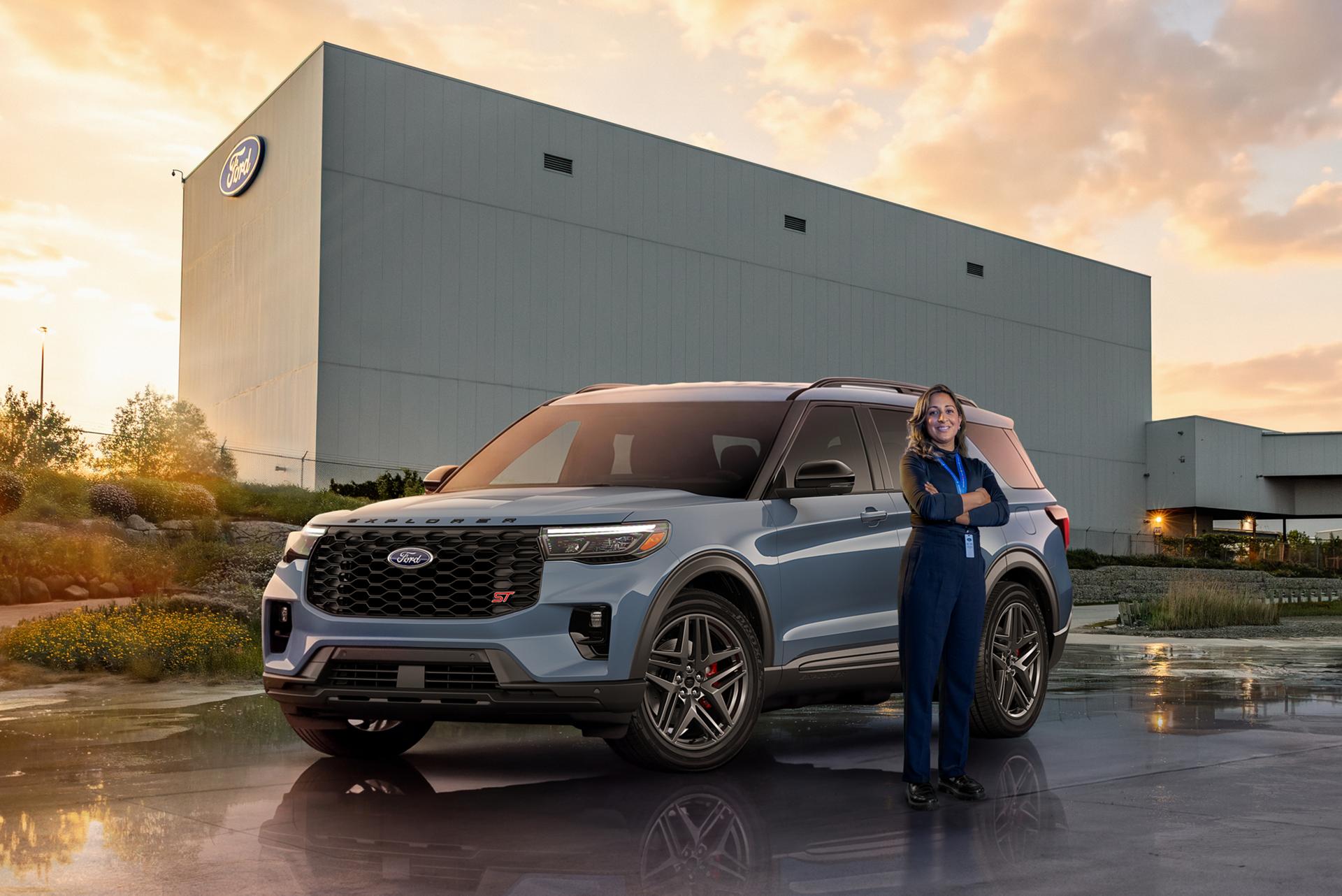 Ford Employee standing next to a parked Ford vehicle.