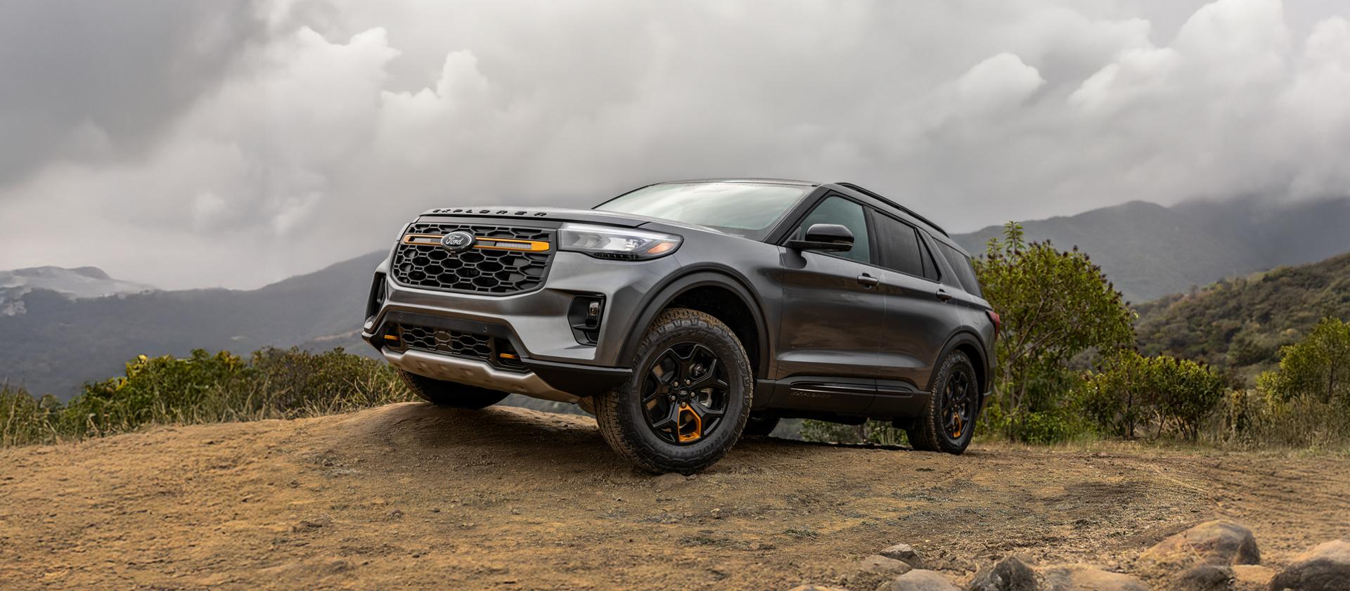 A 2026 Ford Explorer® Tremor® SUV parked atop a muddy rock