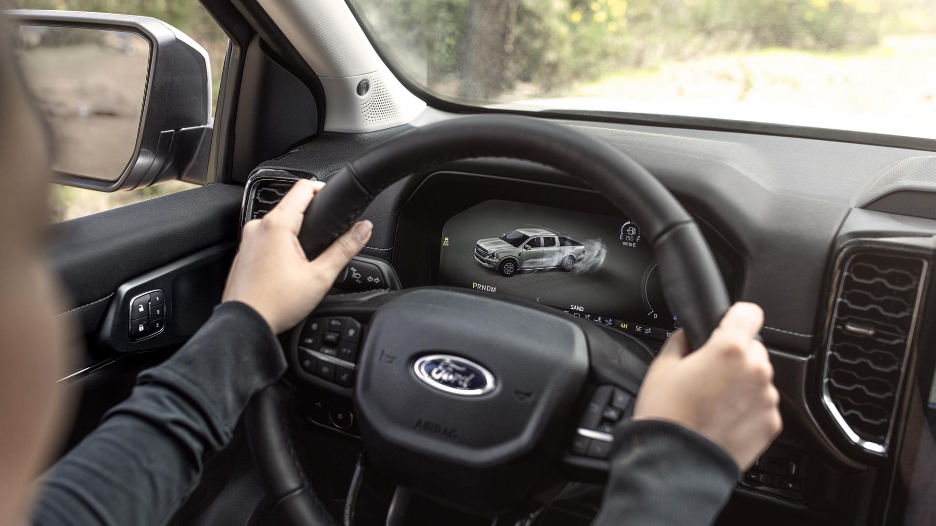 A person with two hands on the steering wheel inside their 2026 Ford Ranger® truck