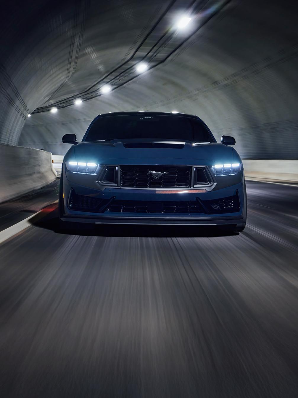 Mustang Dark Horse driving through an urban tunnel at night.