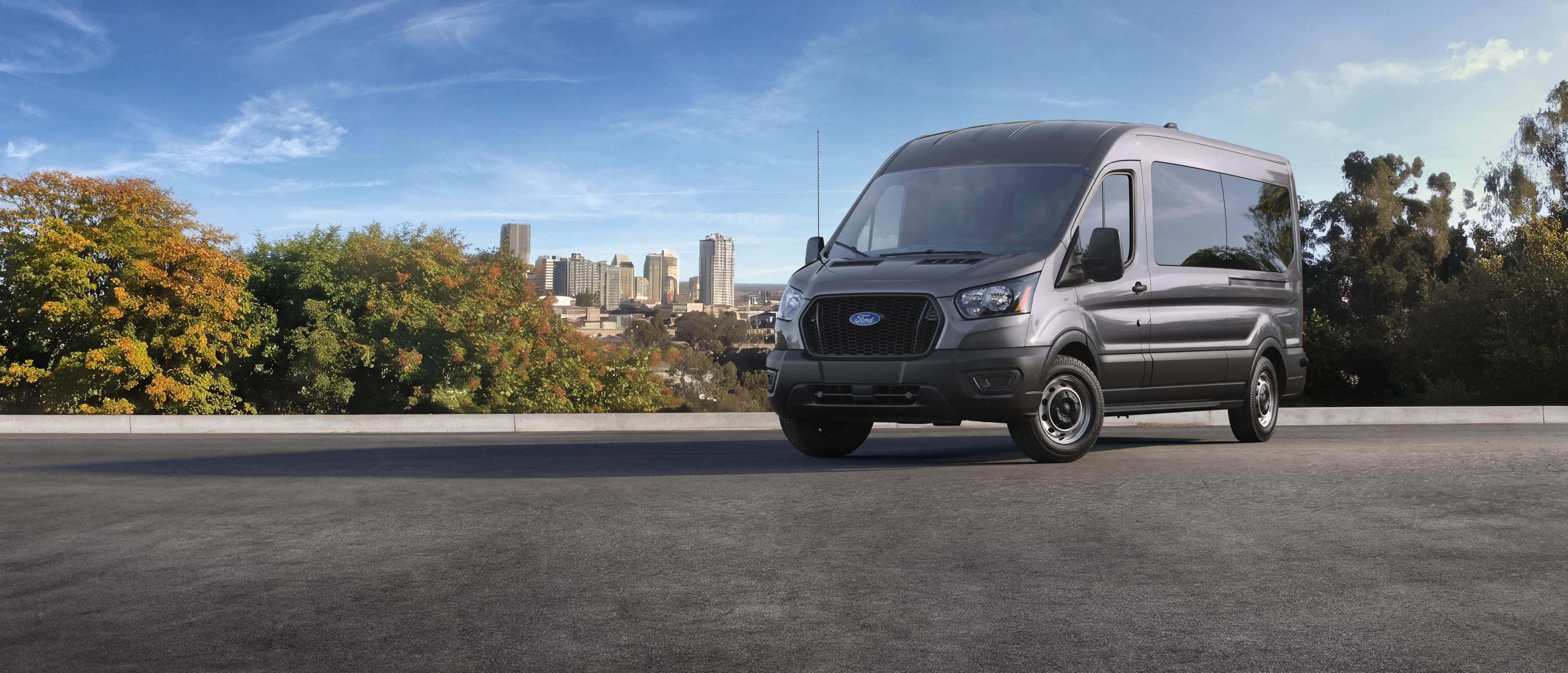 A Grey 2027 Ford Transit® van parked overlooking a city horizon