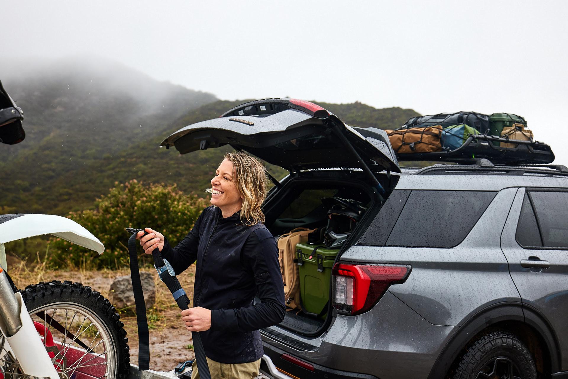 A woman unloading recreational equipment from the back of a Ford Explorer® Tremor® SUV