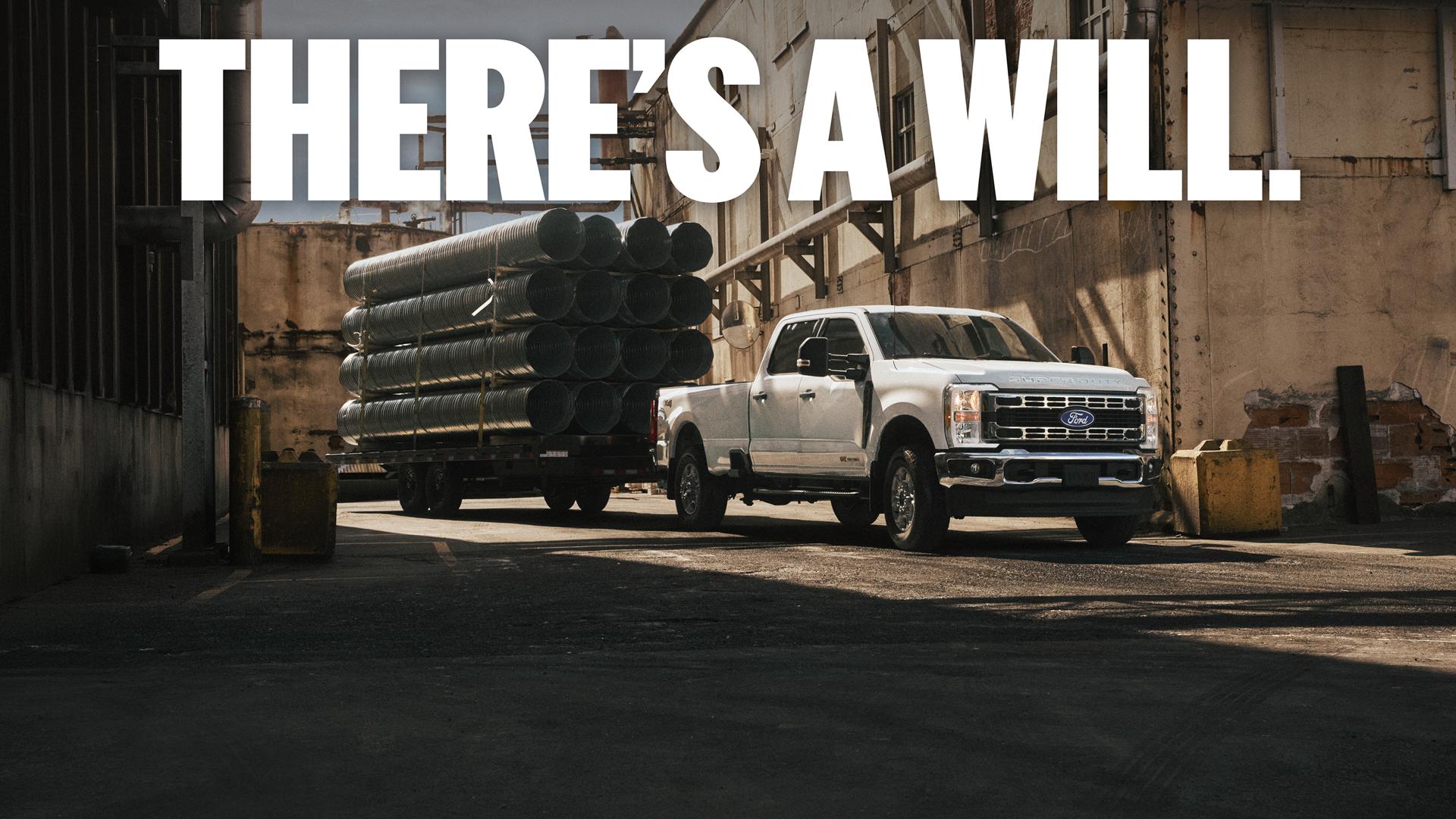 Super Duty parked at a work site with a hitched trailer loaded with steel tubing. Overlayed text reads “There's a Will.”.