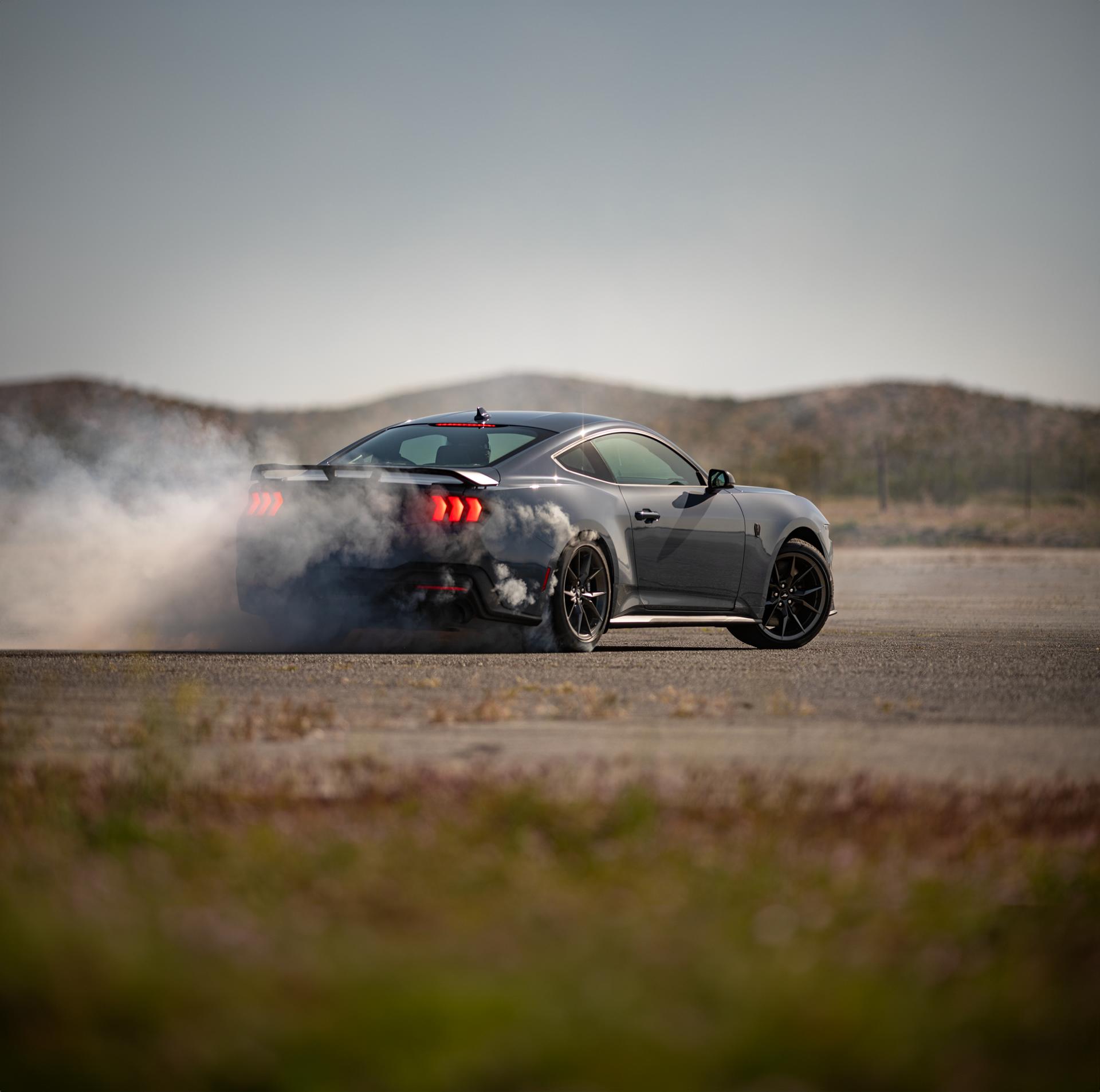 2026 Ford Mustang Dark Horse® fastback in Vapor Blue Metallic with a driver performing burnouts on a closed course