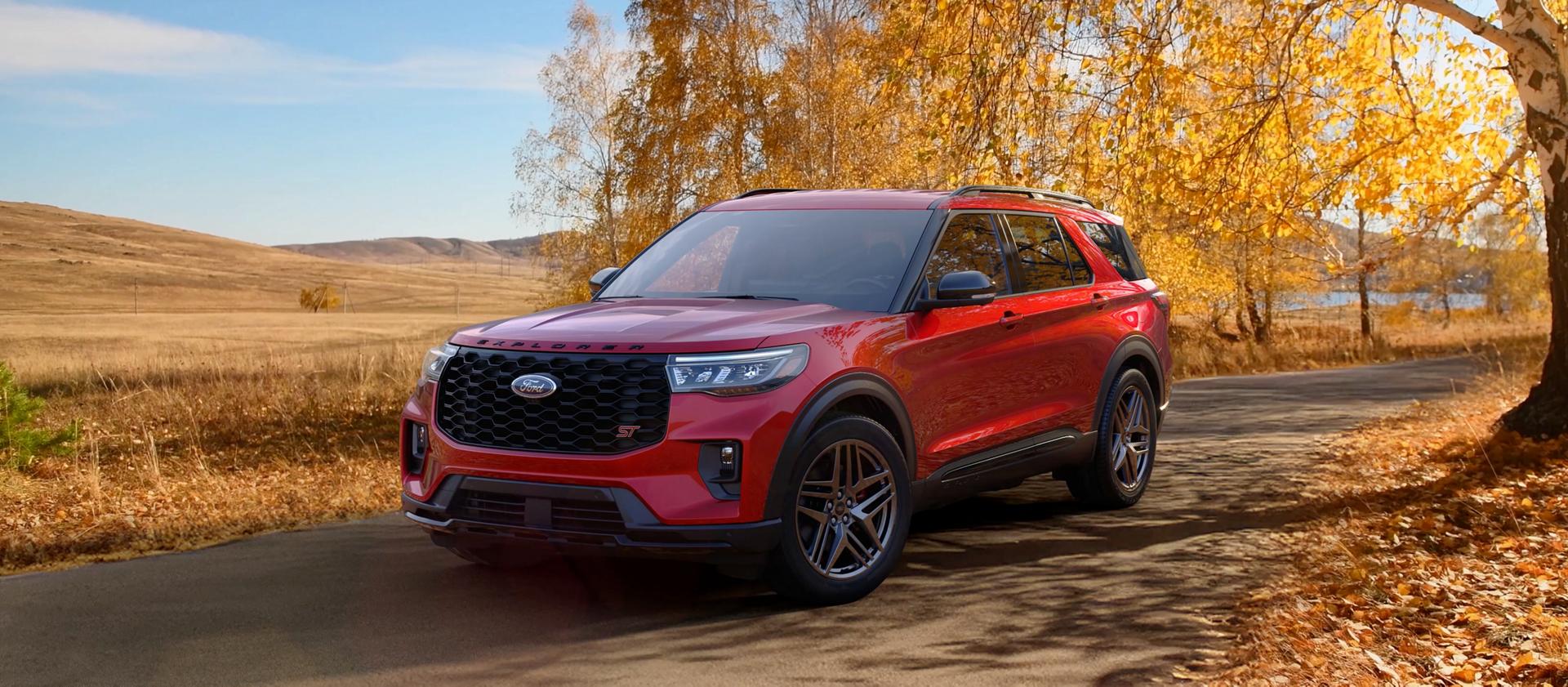 A 2026 Ford Explorer® SUV on a road through a field in the fall