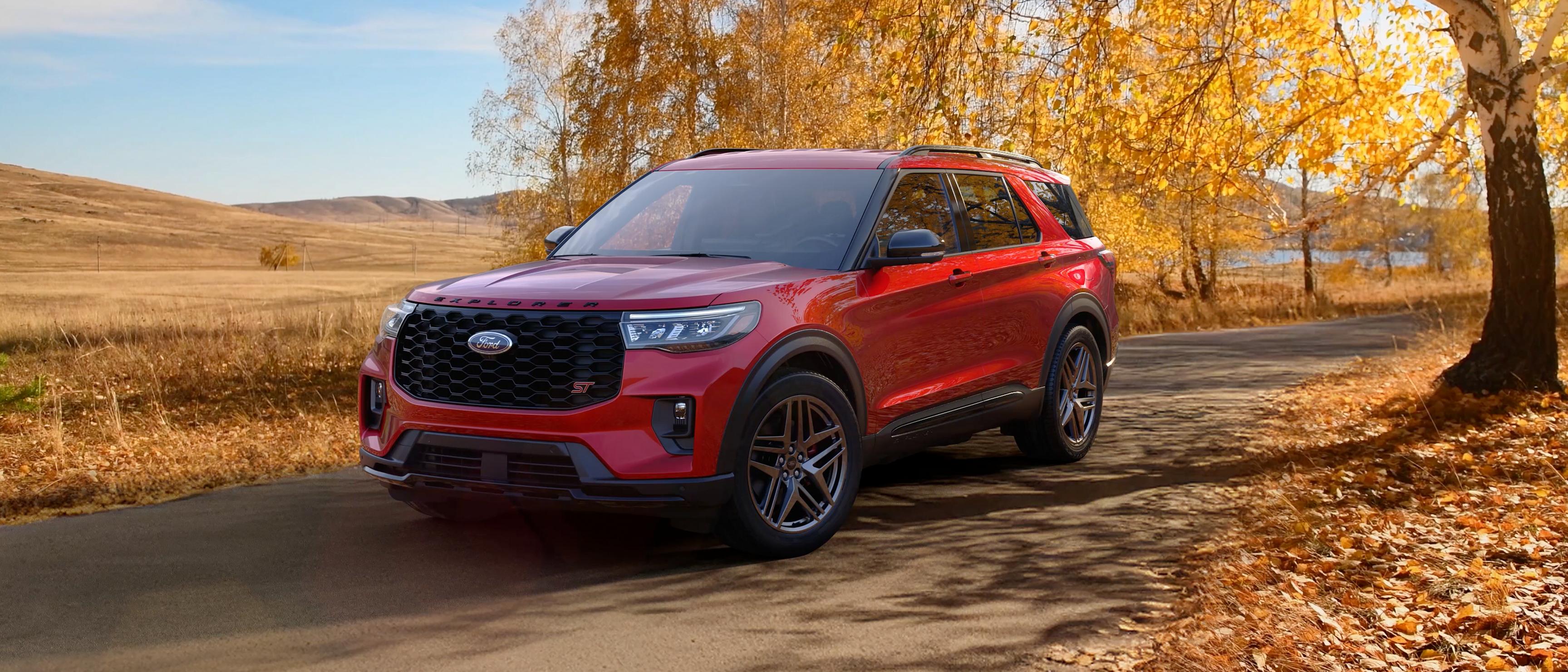 A 2026 Ford Explorer® SUV on a road through a field in the fall
