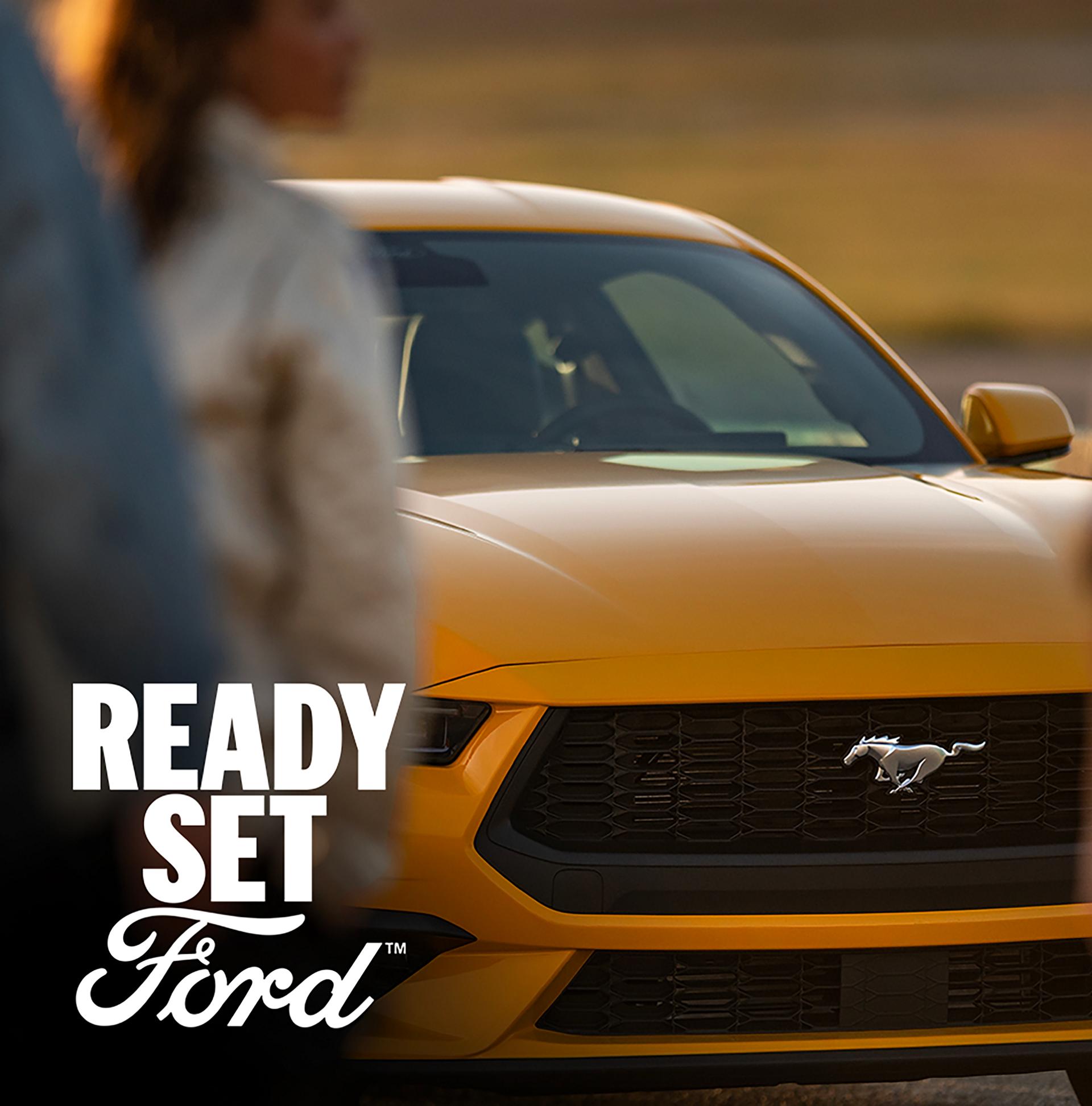 Yellow 2026 Ford Mustang® GR Premium Coupe parked with a woman in the foreground