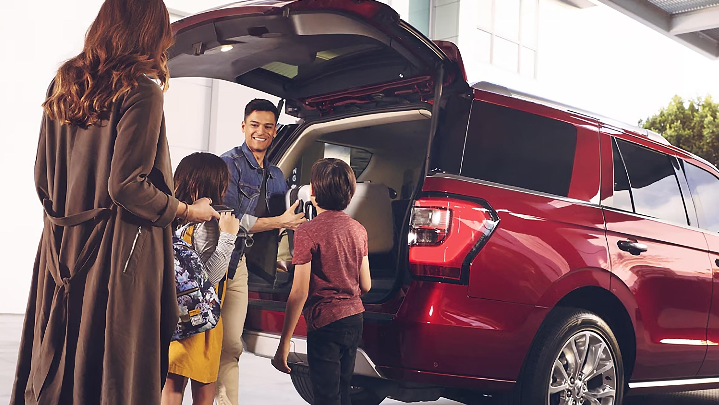 A family unload luggage from their Ford Expedition® SUV in front of their hotel