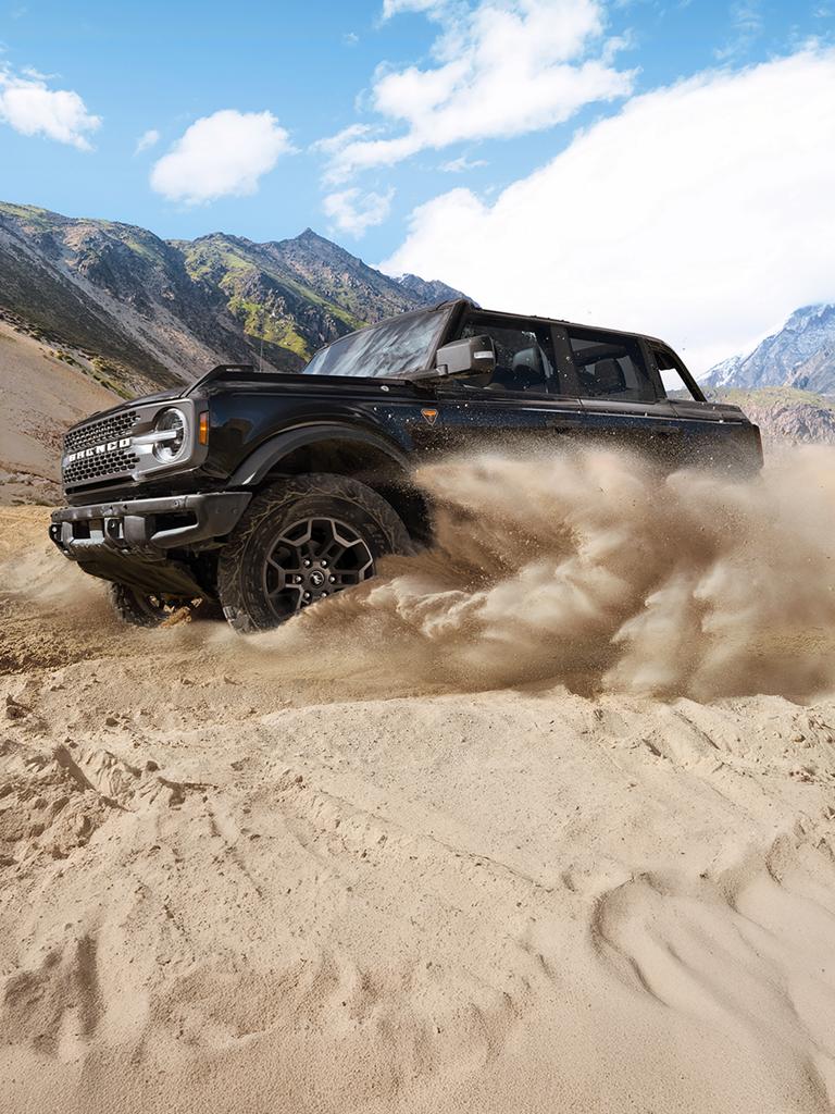 A 2026 Ford Bronco® SUV kicking up sand in a desert valley