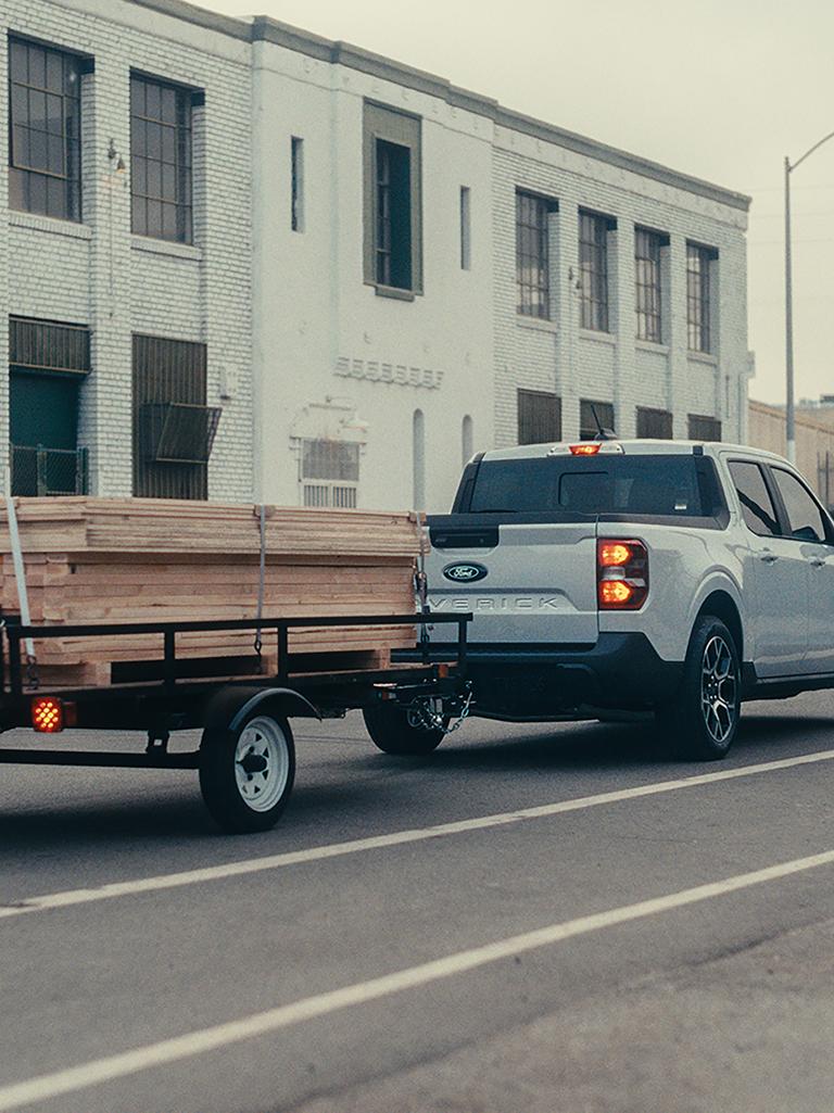 2026 Ford Maverick® pickup pulling a trailer loaded with lumber