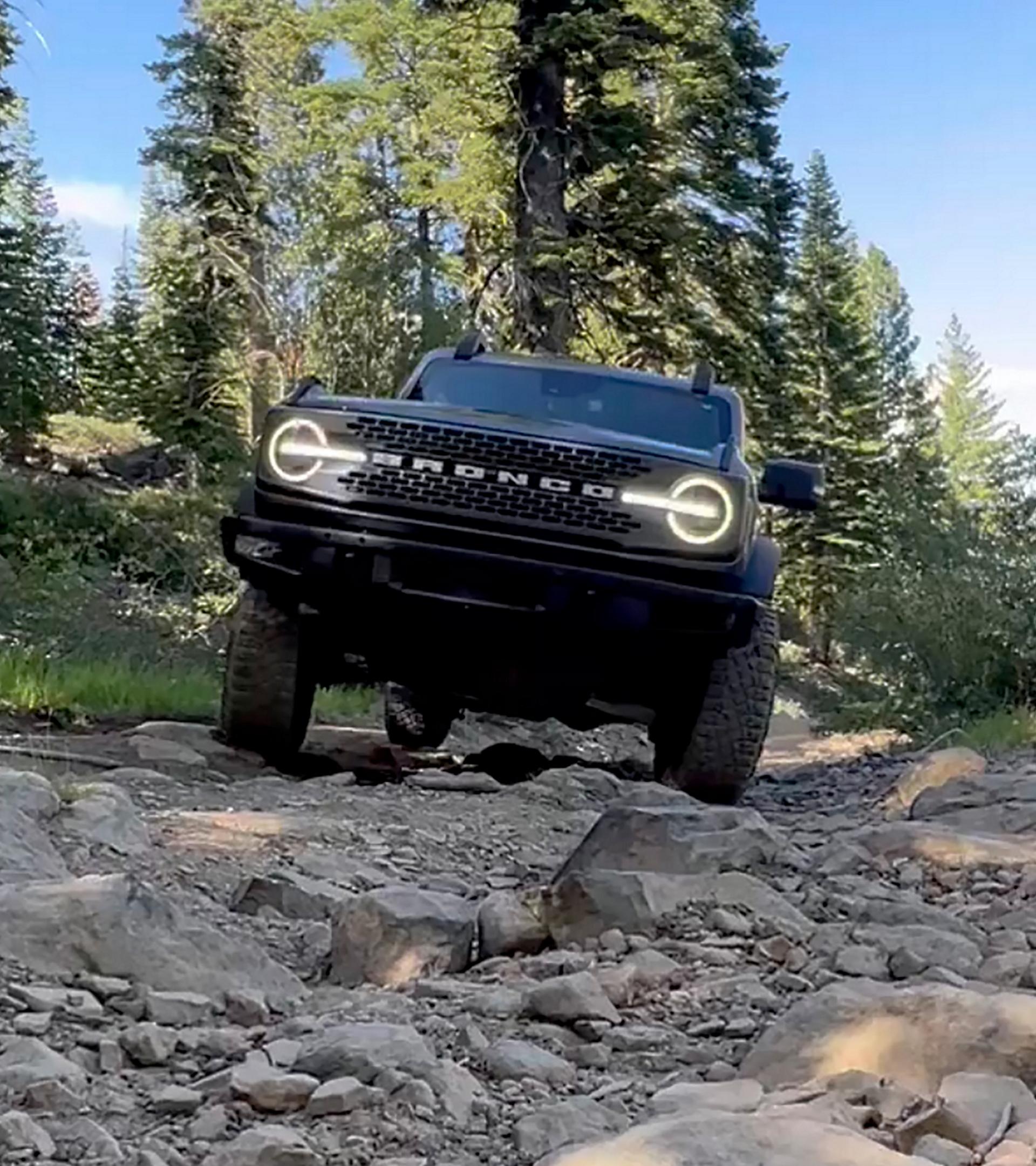 A 2026 Ford Bronco® SUV being driven over rocks and boulders in a dry riverbed