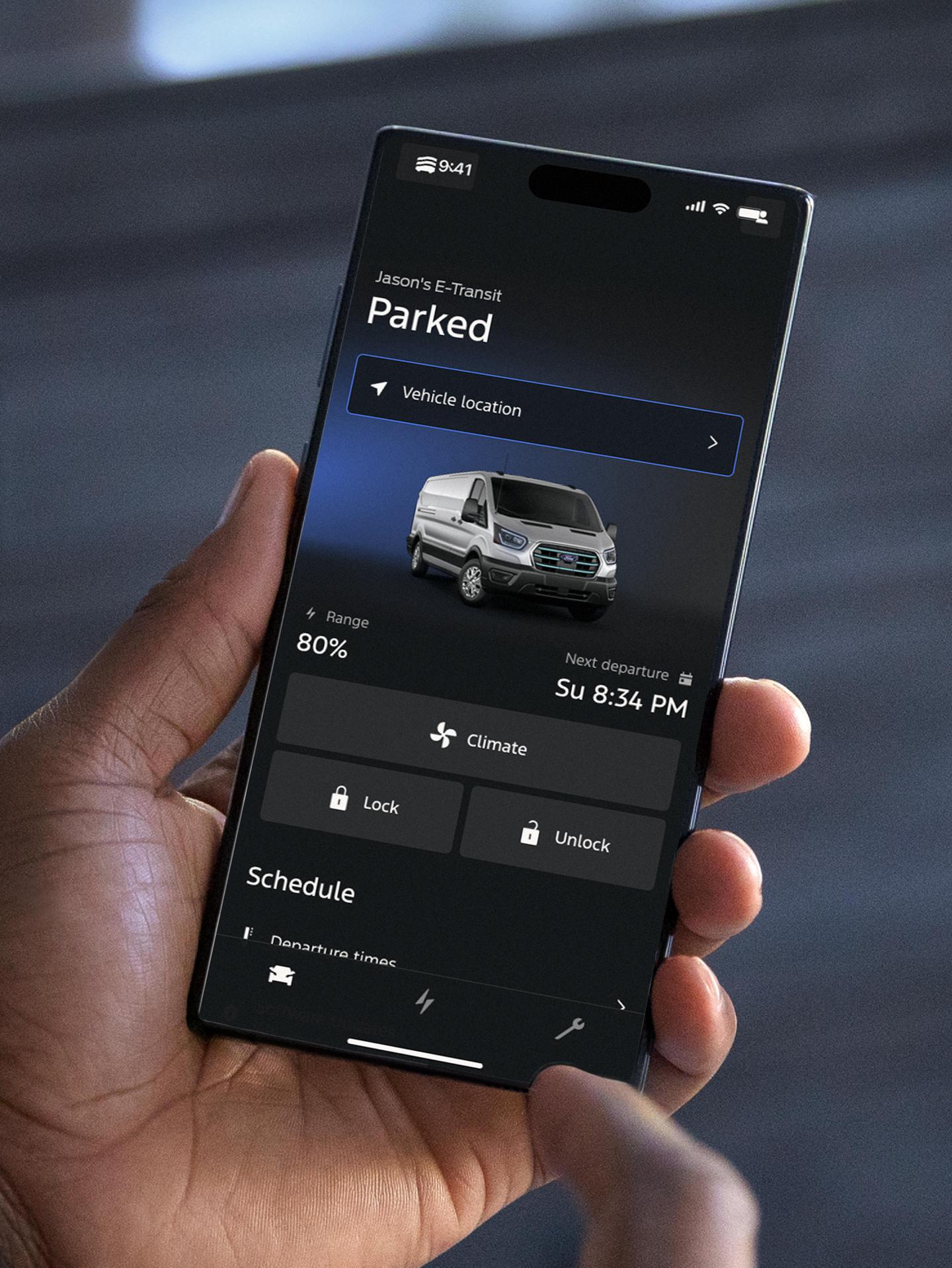 Person holding a smart phone displaying a vehicle’s charging status.