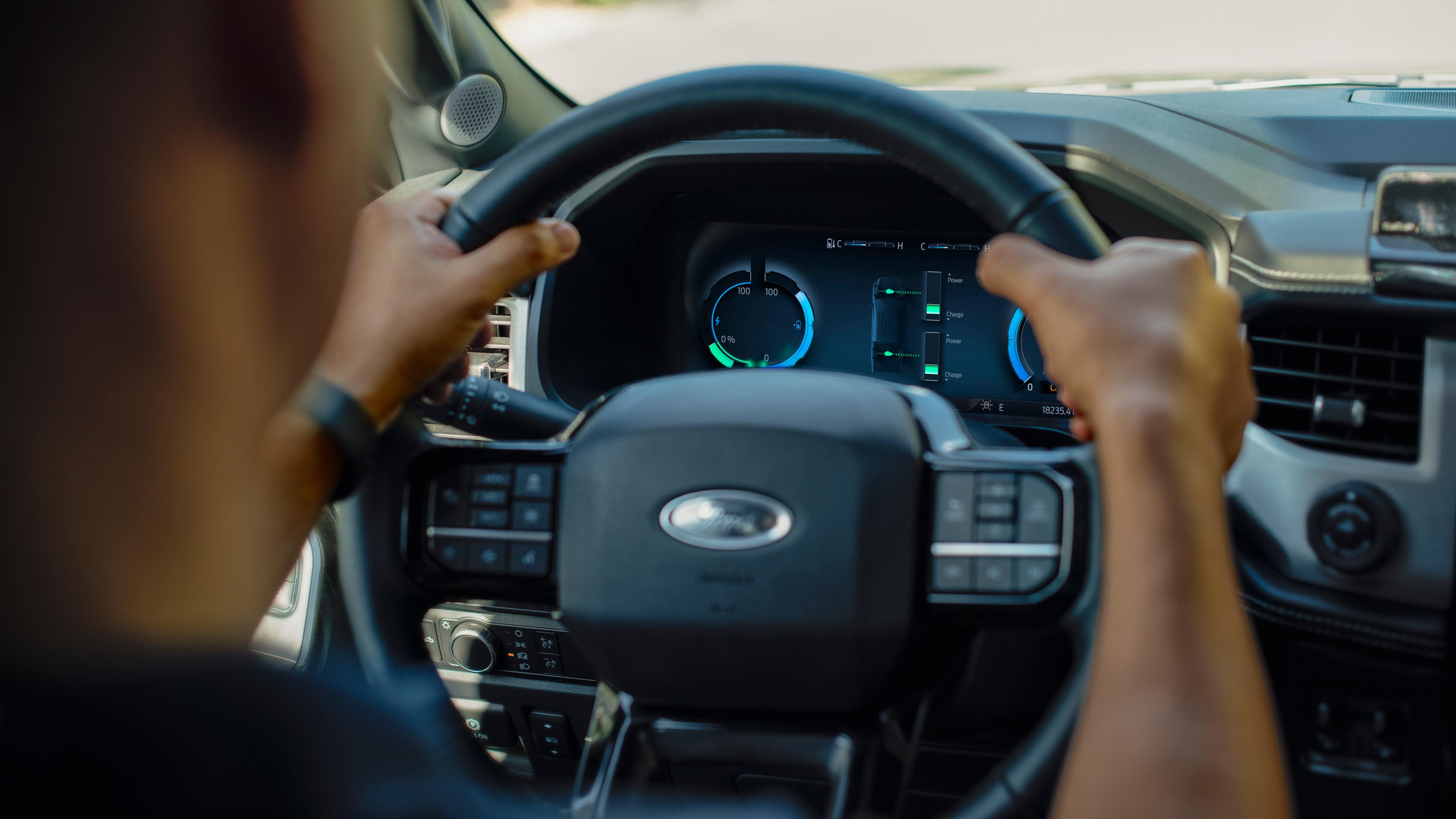 A driver at the wheel of a 2025 Ford F-150® Lightning® pickup