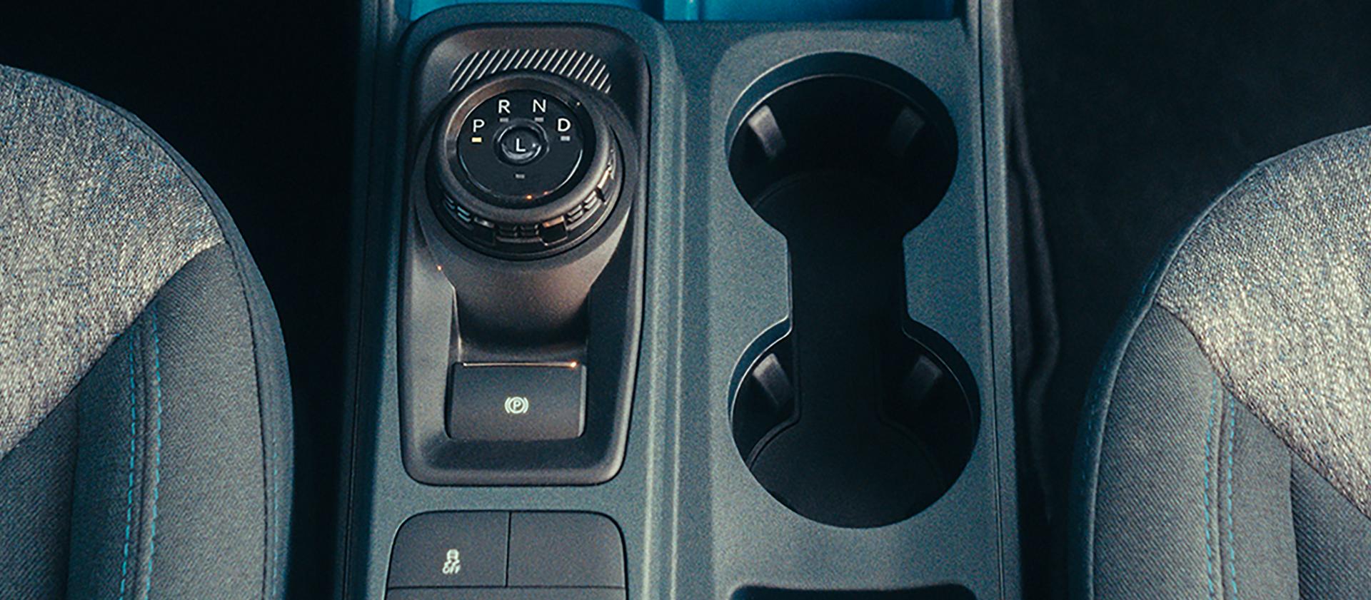 Close-up of the center console showing cupholders and drive mode dial