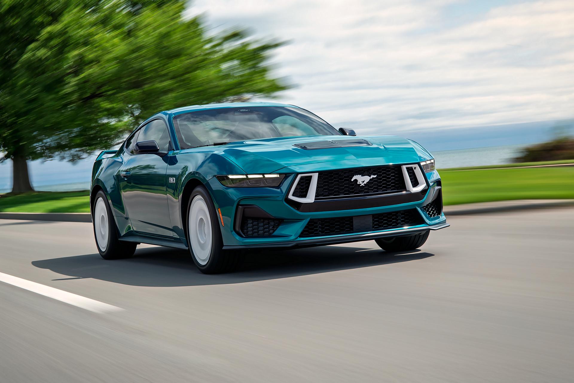 A 2026 Ford Mustang® GT Premium fastback with the available FX Package being driven near a lake