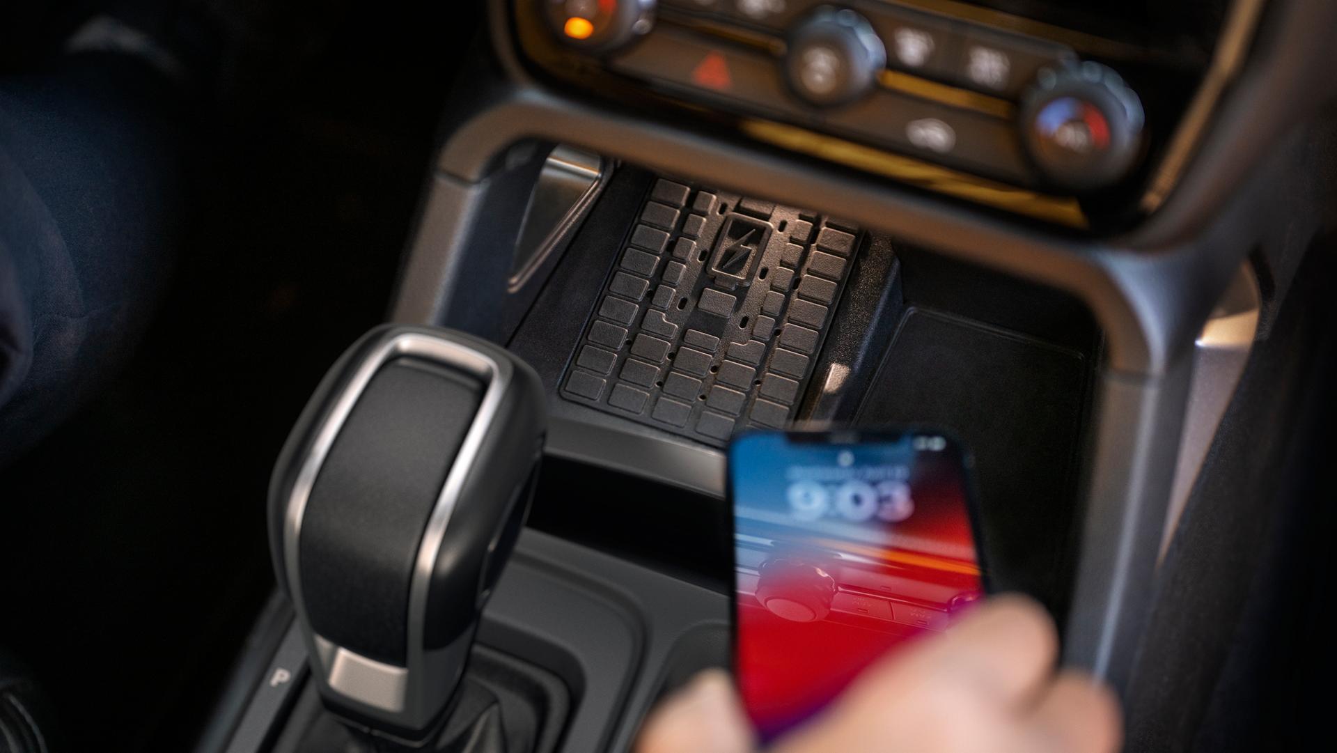 A person using the wireless charging pad inside their 2026 Ford Ranger® Lariat® truck