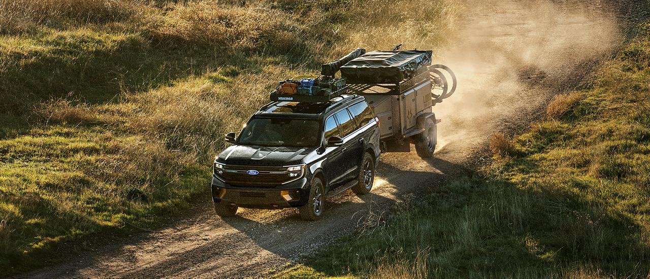 A 2027 Ford Expedition® Tremor® model being driven in the desert while towing a trailer