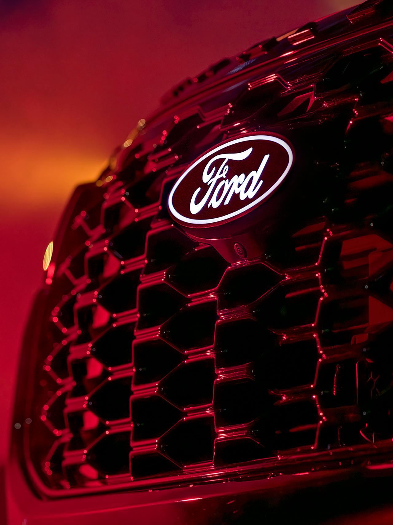 A close-up of the available illuminated hood badge and camera on a 2027 Ford Explorer® ST-Line model