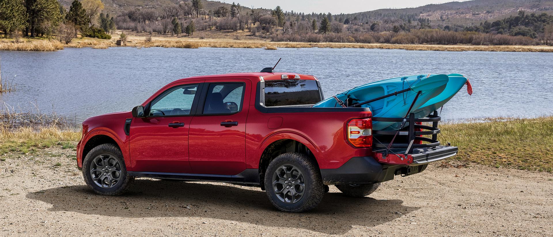 2026 Ford Maverick® Lariat® parked near a lake with two kayaks in the bed
