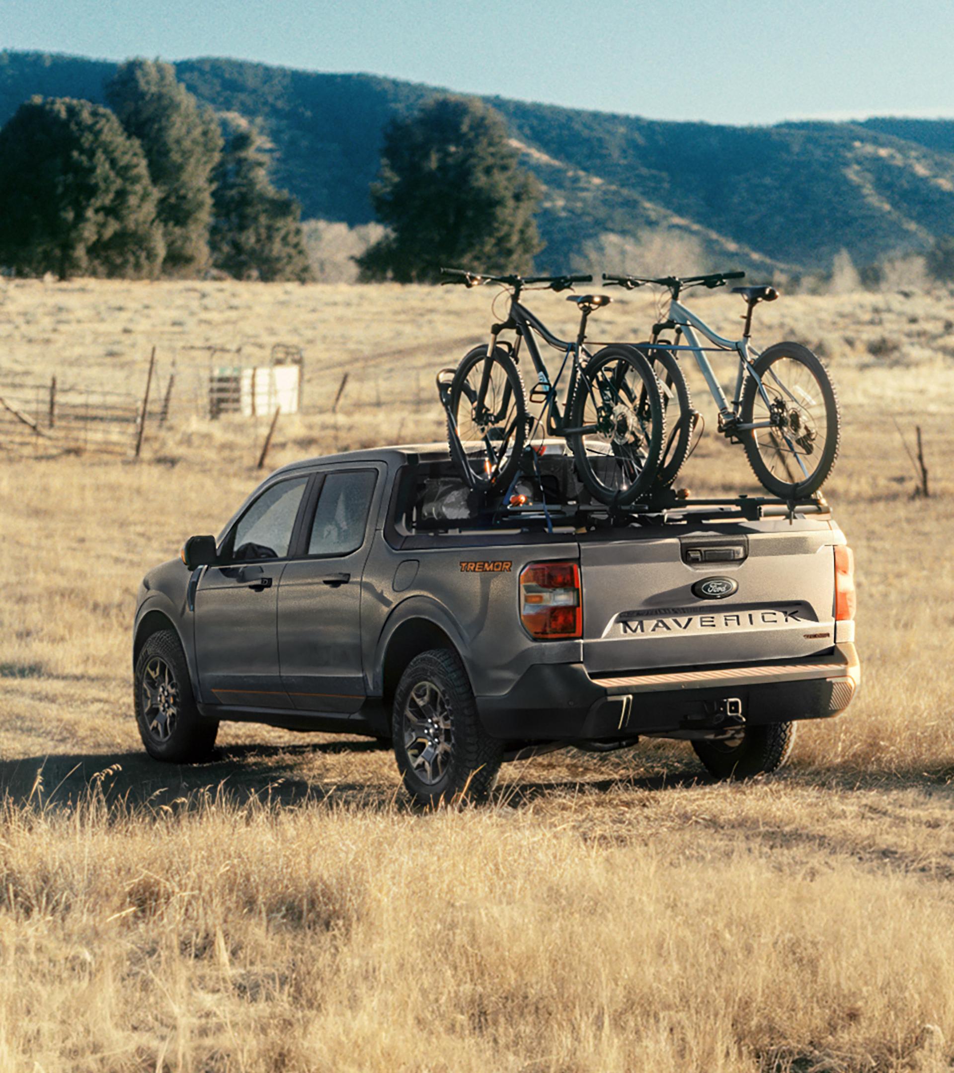 2026 Ford Maverick® Tremor® model being driven on a grassy field with bikes mounted in the bed