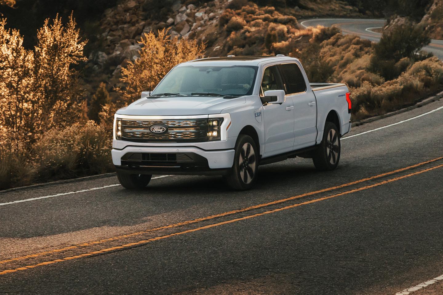 F-150 Lightning driving on a two-lane coastal highway.